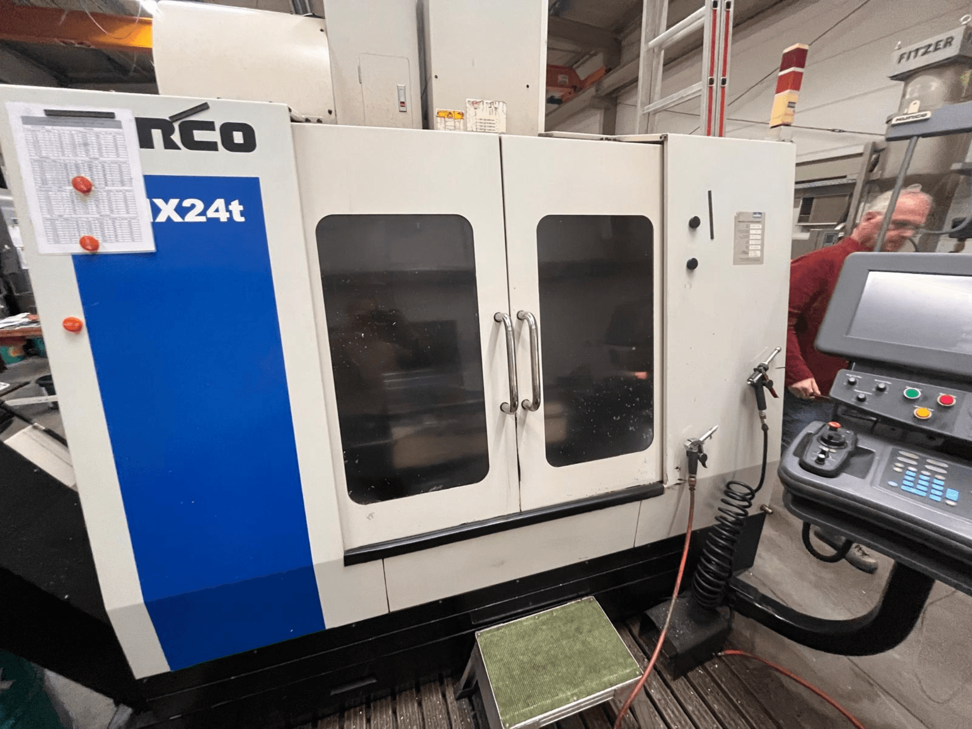 Hurcon pystysuora työstökeskus, malli VX24t, edestä kuvattuna ohjauspaneelin ja läpinäkyvien ovien kanssa.