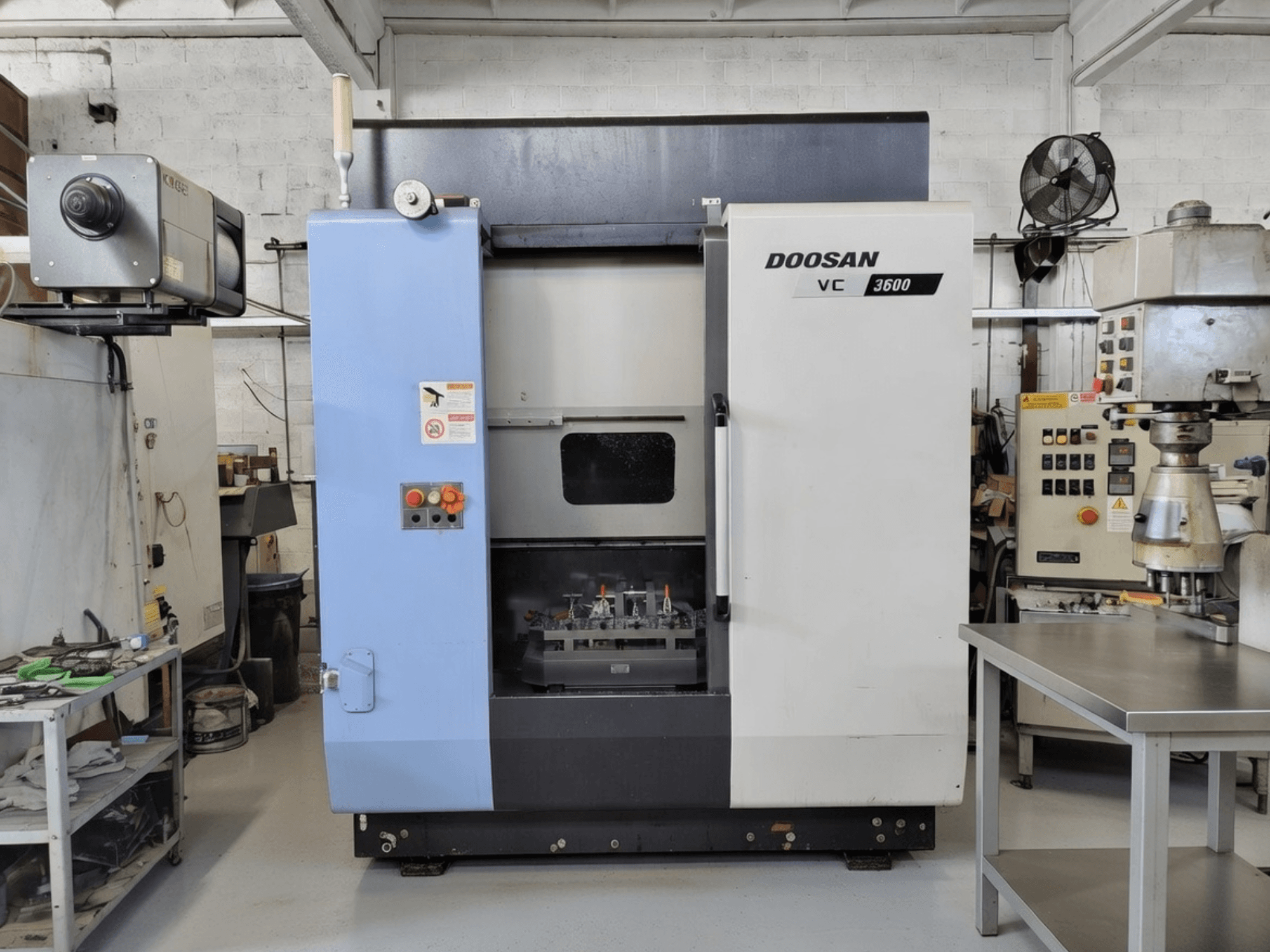 DOOSAN VC 3600 -pystytyöstökeskus etukuvassa, jossa on ohjauspaneeli ja avoin ovi, josta avautuu työtila.