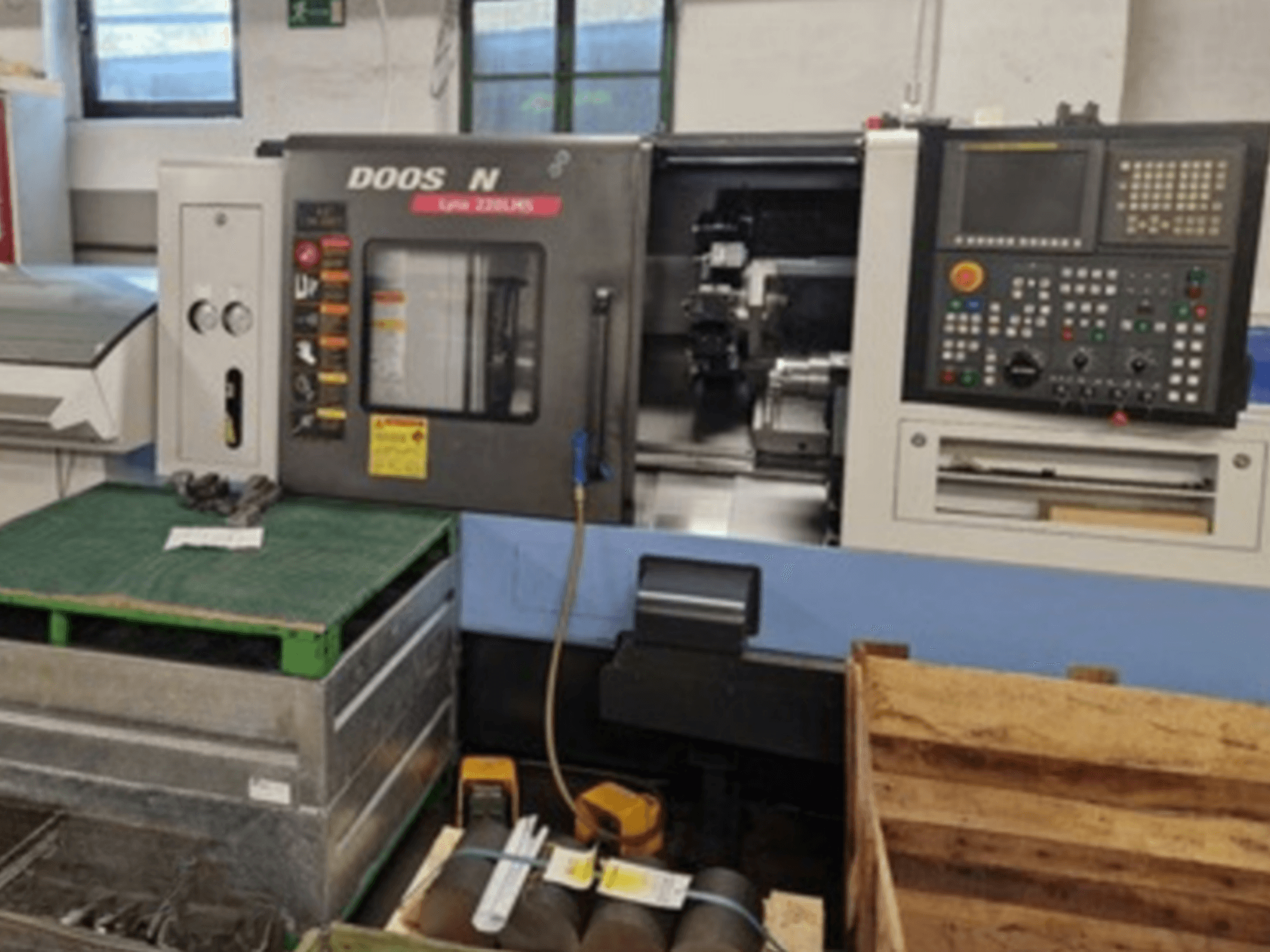 DOOSAN Lyax 220 LMS -vaakasorvauskone etukuvassa, jossa näkyy ohjauspaneeli, työkalut ja työtila.