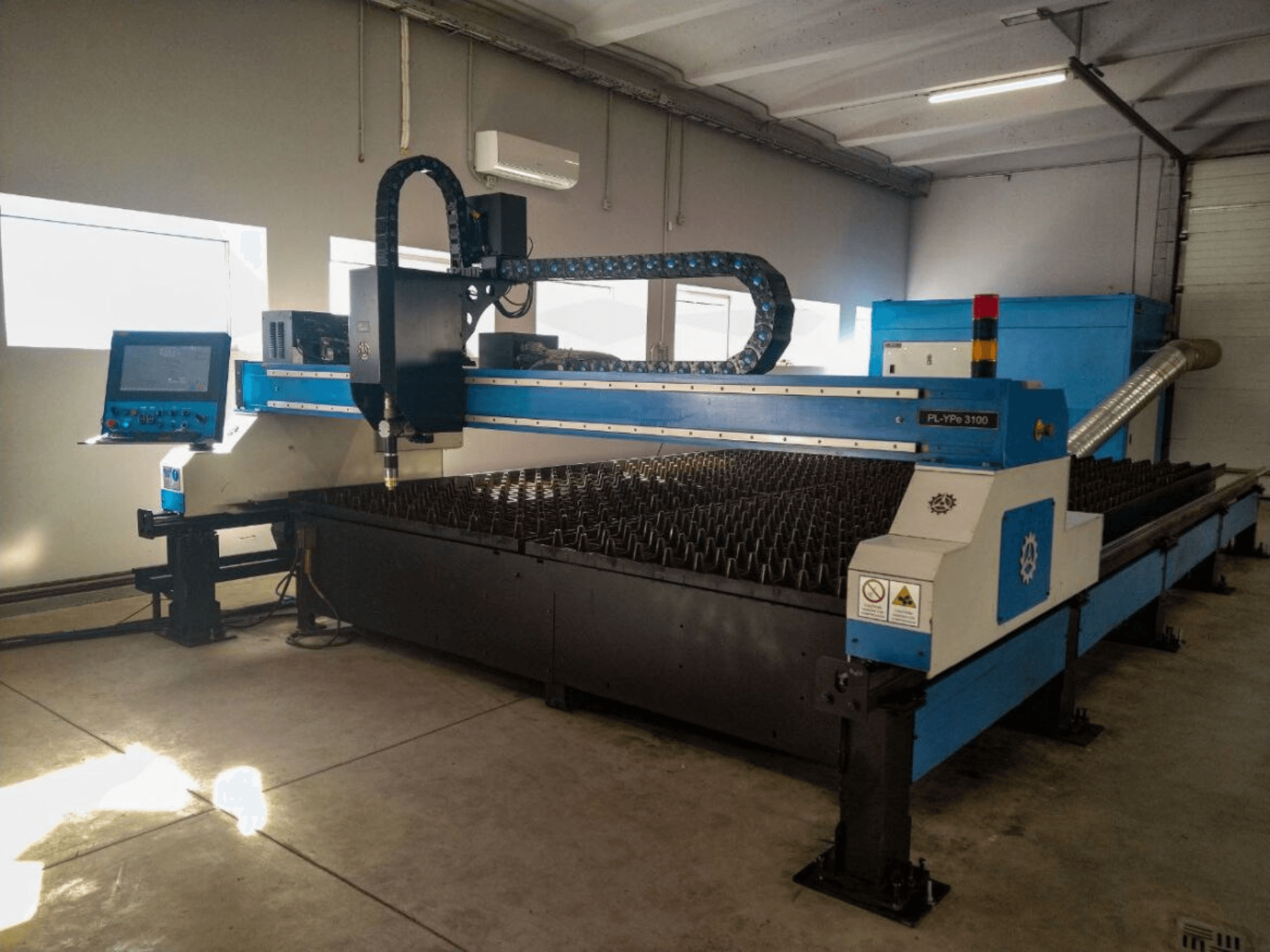 PL-YP© 3100 CNC-leikkauskone näytöllä, etukuva, jossa on metallin leikkaussänky ja tarkka suuttimien ohjausjärjestelmä.