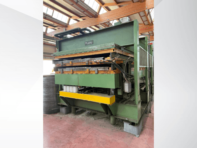 Mannin hydraulinen puristin, sivukuva, jossa vihreä metallirunko, keltainen pohja ja useita hydrauliikkalinjoja näkyvissä.