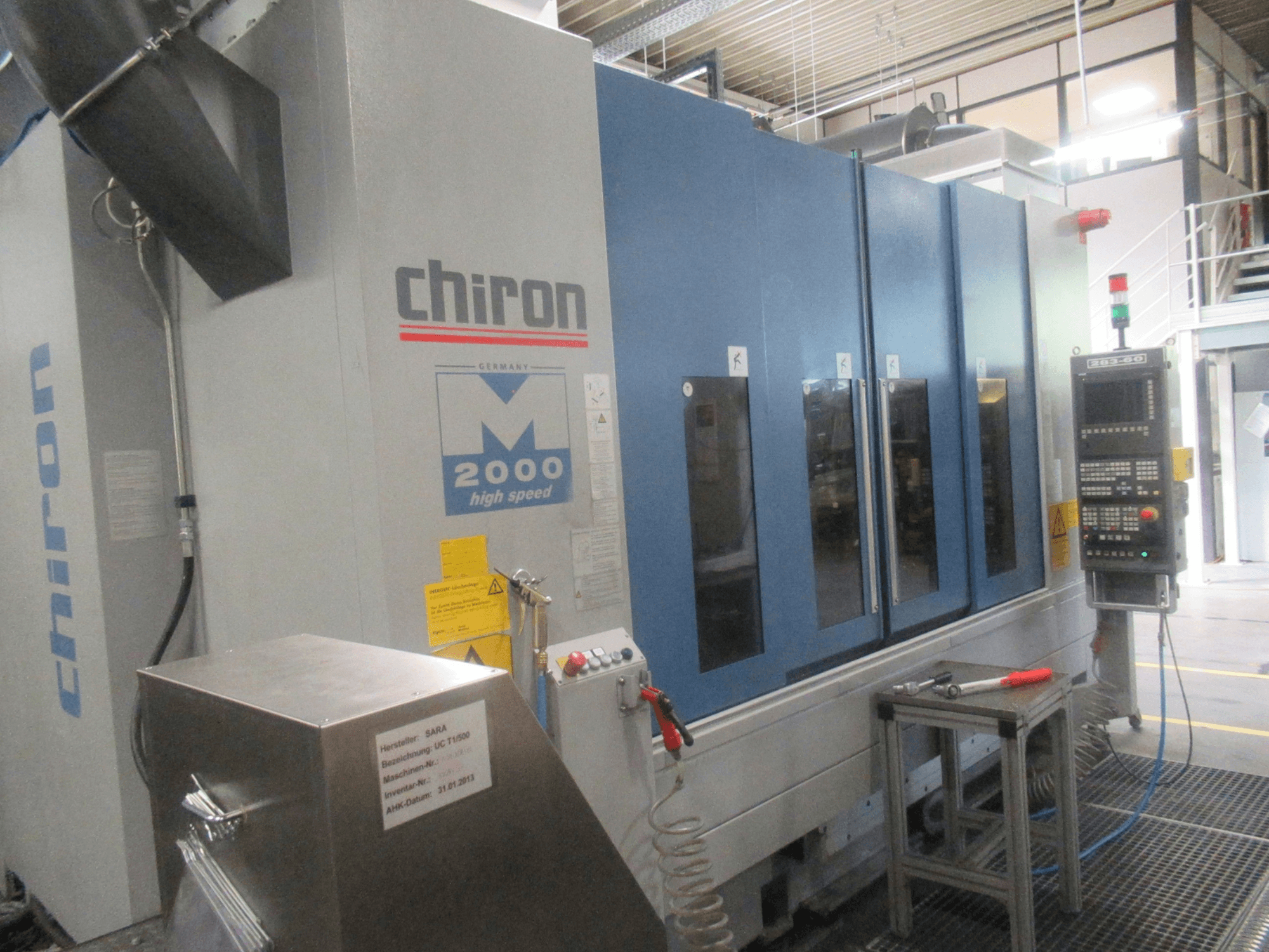 CHIRON Mill 2000 -pystykoneistuskeskus, etunäkymä ohjauspaneelin kanssa, sininen muotoilu ja näkyvissä olevat suurinopeusominaisuudet.