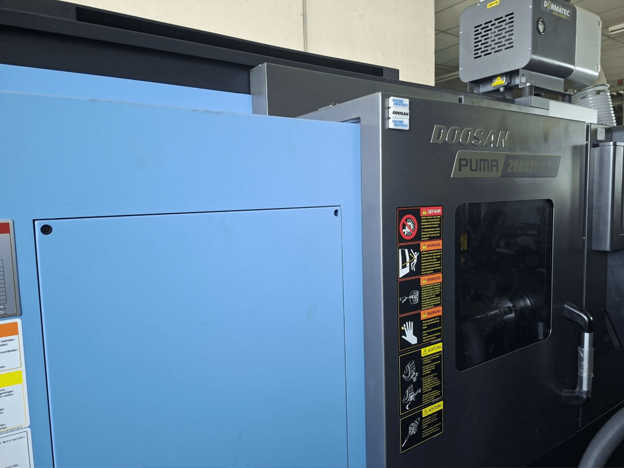 DOOSAN PUMA 2600 SY II -vaakasorvauskone, etukuva, jossa on turvatarrat ja sininen paneeli.