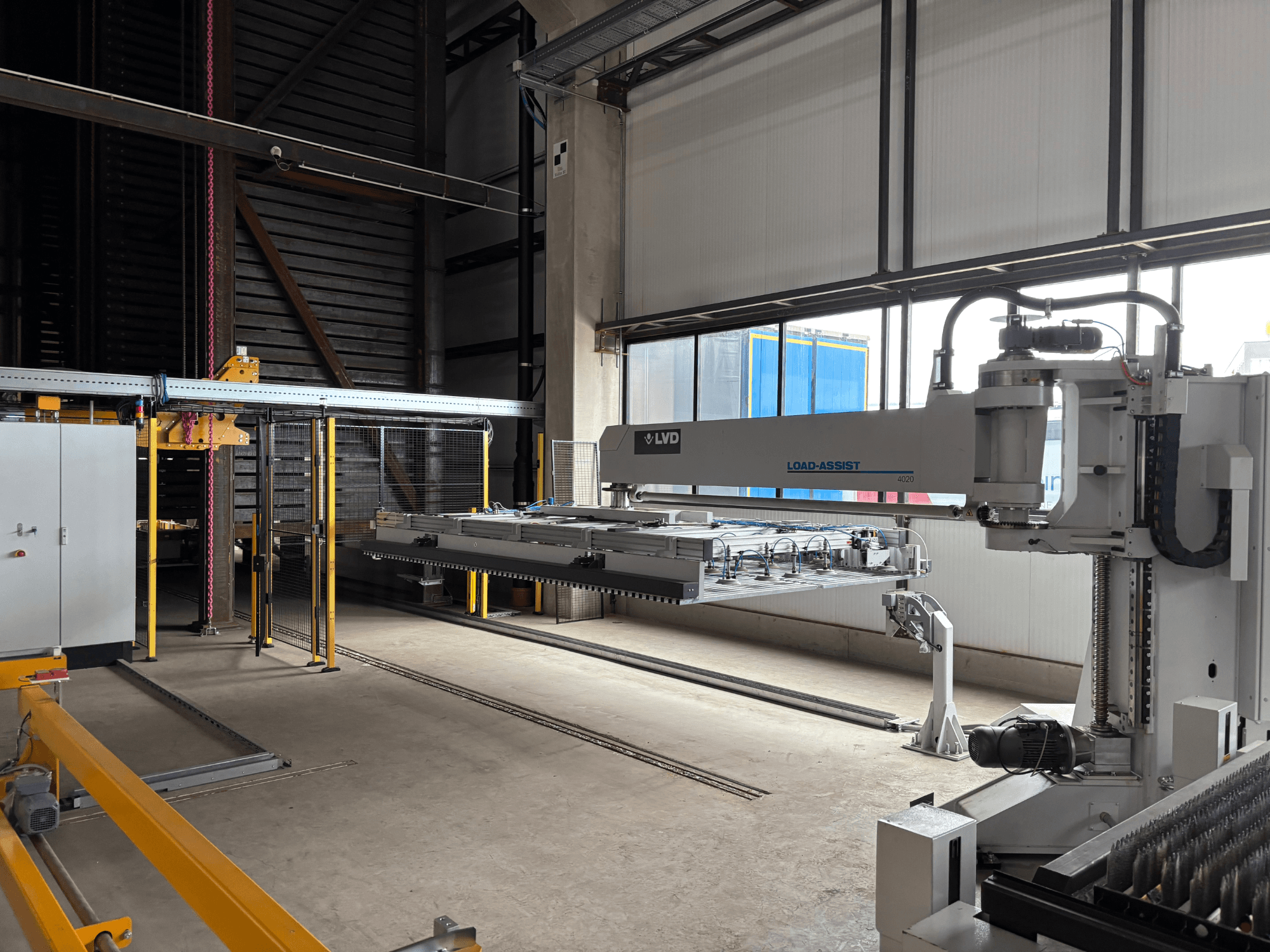 LVD Load-Assist 4020 -automaatiolaitteisto etukuvassa, jossa robottivarsi ja lastausjärjestelmä näkyvät suuressa työtilassa.