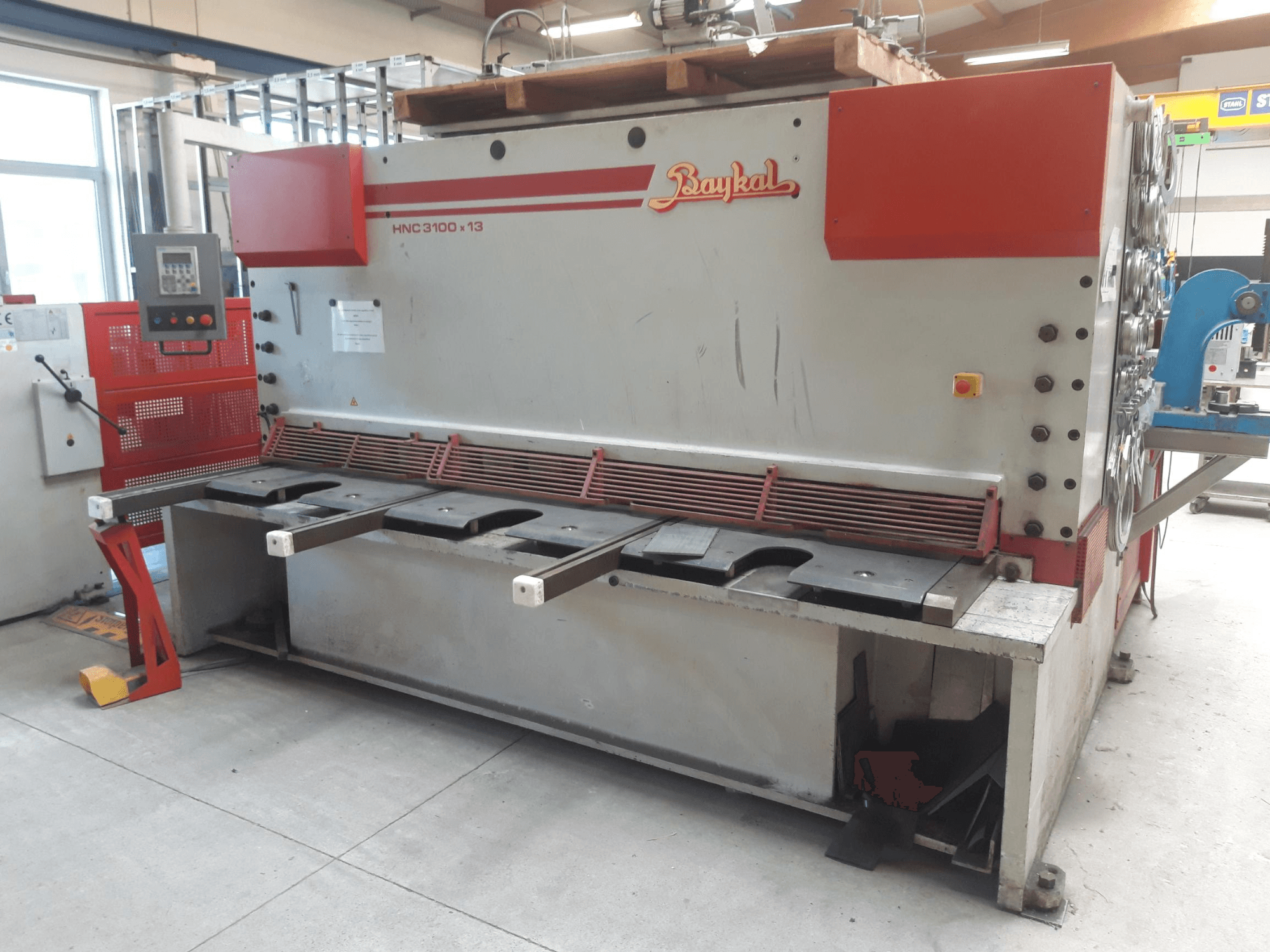 Baykal HNC 3100x13 CNC-leikkauskoneen etunäkymä, jossa näkyvät ohjauspaneeli, metallinleikkausalue ja jätteiden keräystila.