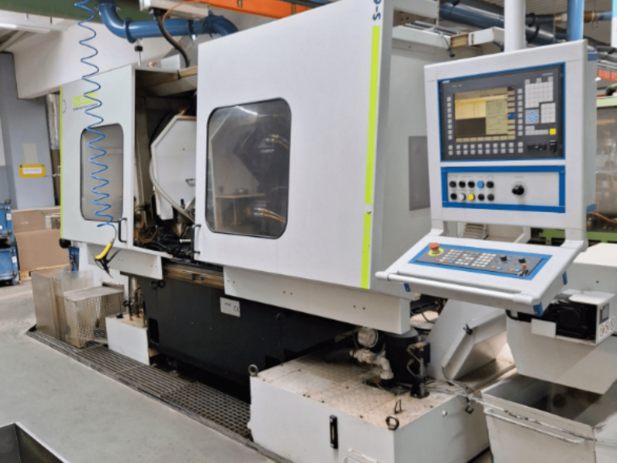 Ohjauspaneelilla varustettu teollisuusjyrsin, sivukuva, jossa on kaksoiskammiot ja näkyvät putkiliitännät.