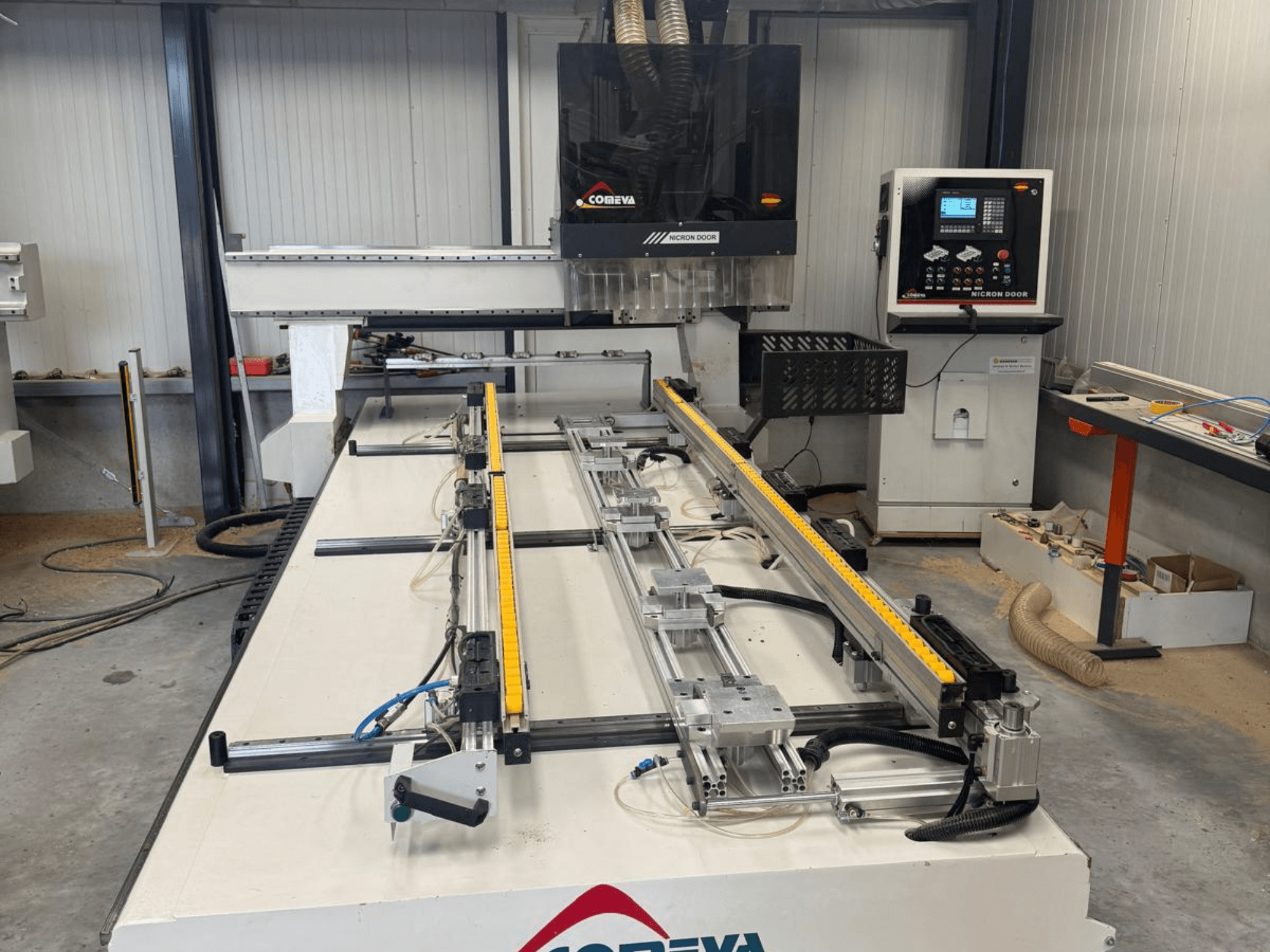 CNC-puunkäsittelykeskus COMEVA MEX V 2100x3260 edestä katsottuna; kuvassa näkyvät työpiste, ohjauspaneeli ja ohjauskiskot.