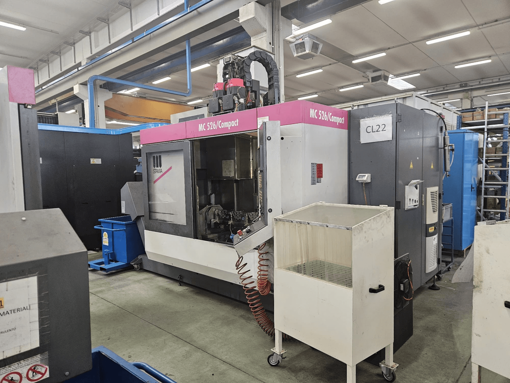 Staman MC 526 Compact CNC -kone, sivukuva, jossa näkyy ohjauspaneeli, jäähdytysnestesäiliö ja viereiset koneet.