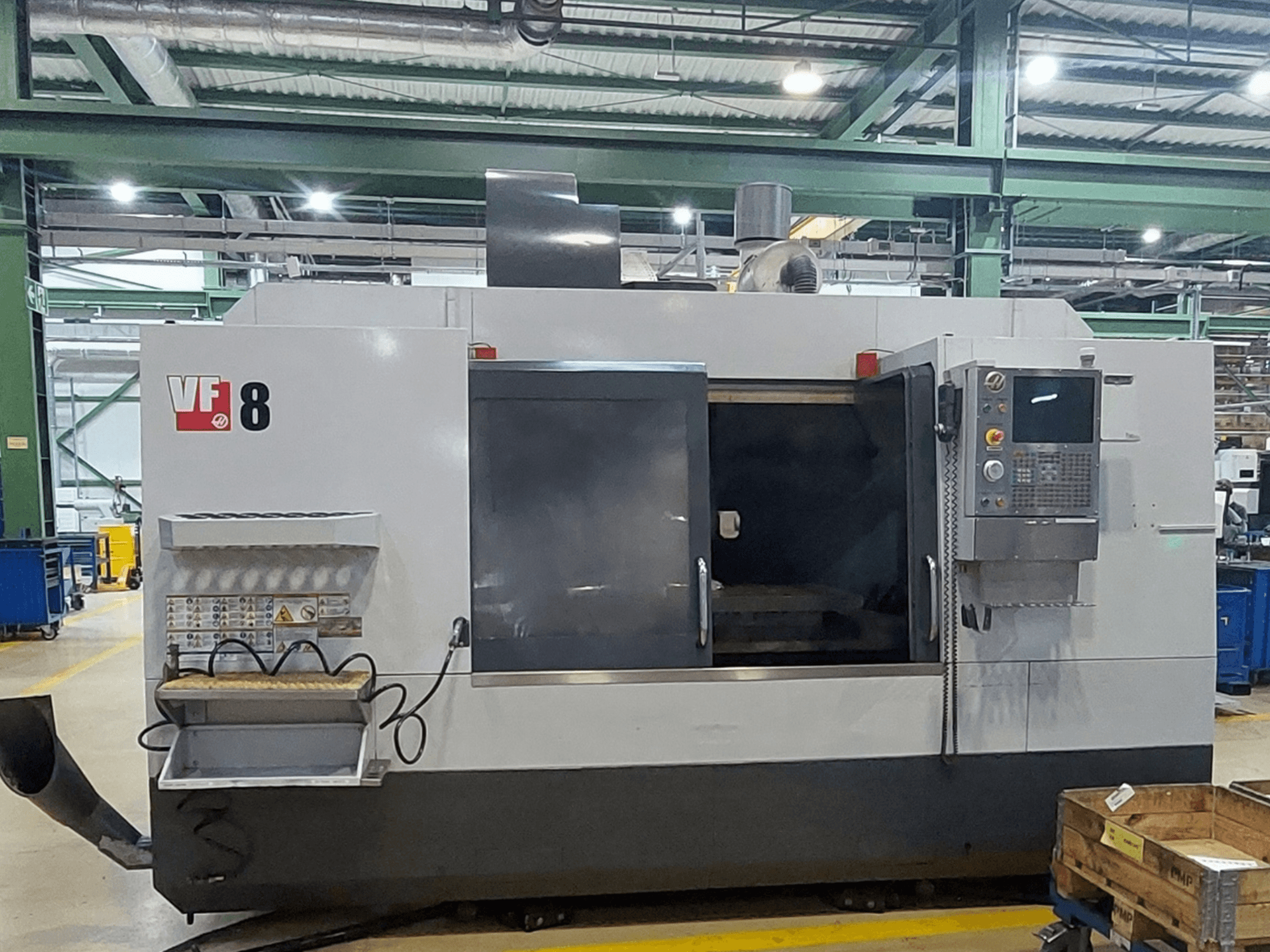 HAAS VF-8 -pystykoneistuskeskus, etunäkymä; kuvassa näkyvät ohjauspaneeli ja lastausalue; laite on suunniteltu tarkkoihin koneistustehtäviin.