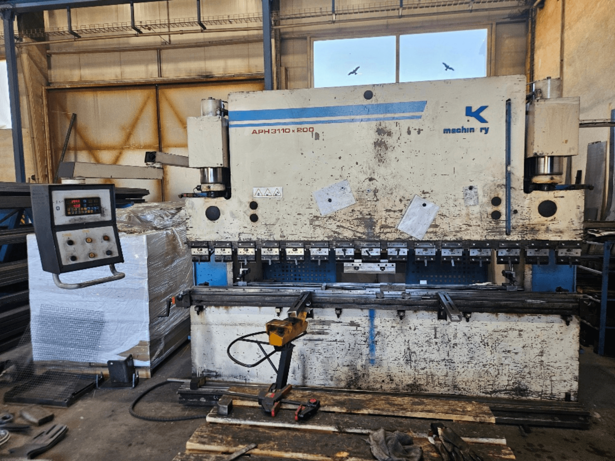 Baykal APH 3110x200 -puristusjarru työpajassa, etukuva, jossa ohjauspaneeli, metallilevyt ja työkalut näkyvissä.