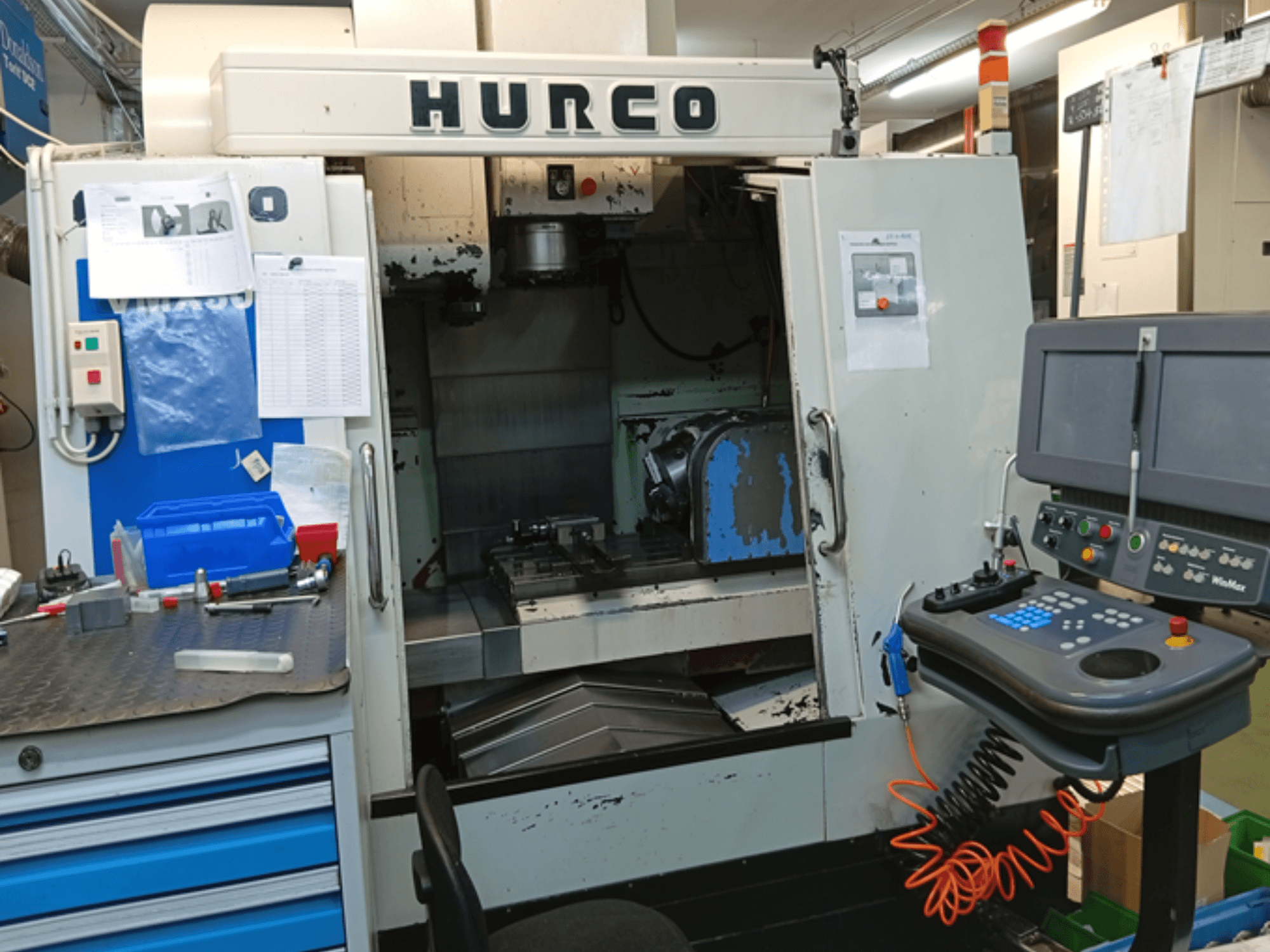 Hurco VMX 30T -pystytyöstökeskus, etukuva, jossa näkyy ohjauspaneeli, työtila ja osittain avattu ovi.