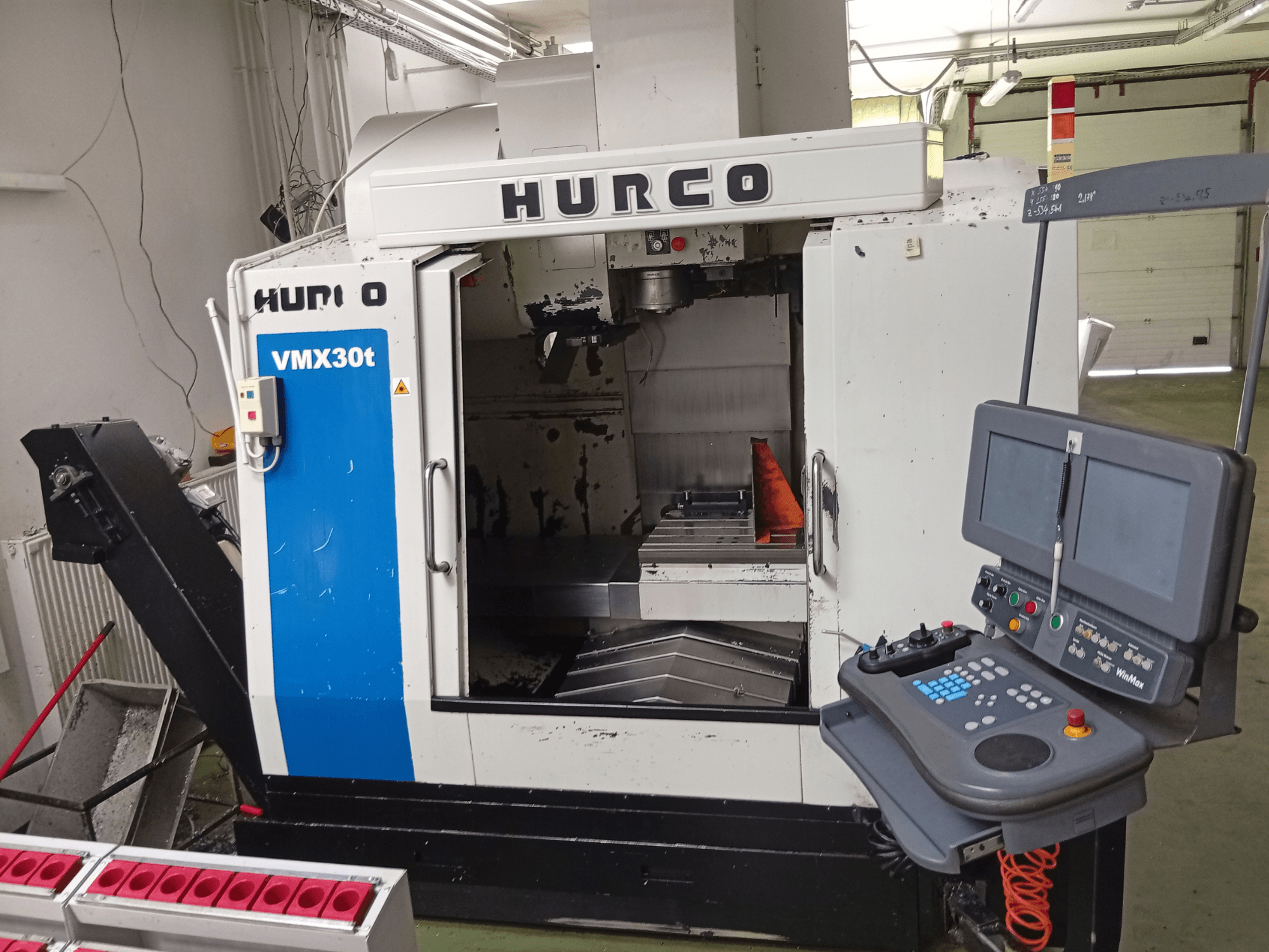 Hurco VMX 30T -pystykoneistuskeskus, etunäkymä, jossa näkyvät ohjauspaneeli ja karialue sekä työpöytä.
