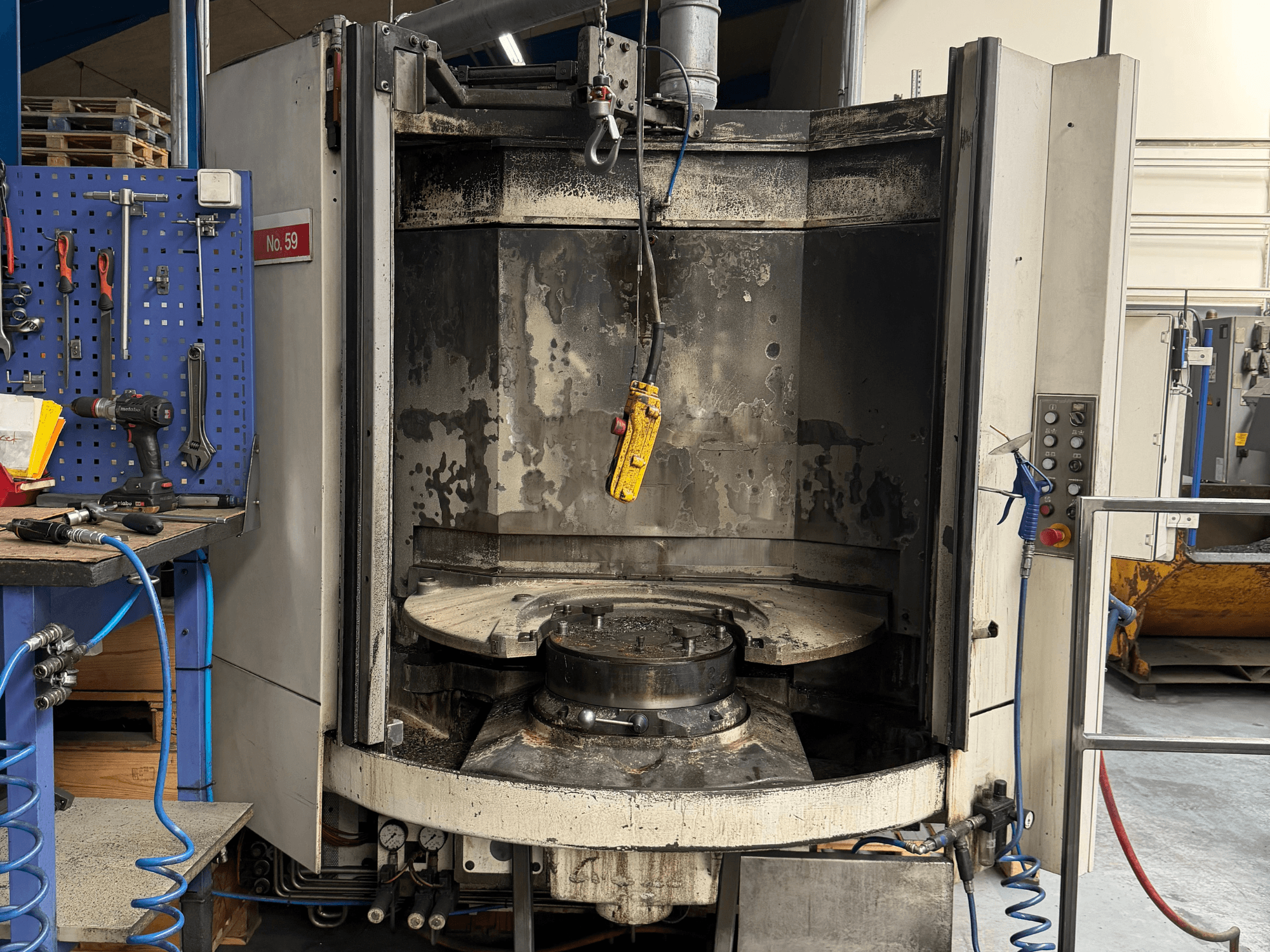 Vaakatyöstökeskus HELLER MC 16 etukuvassa, jossa näkyy tyhjä työpöytä ja ohjauspaneeli, työpajassa.