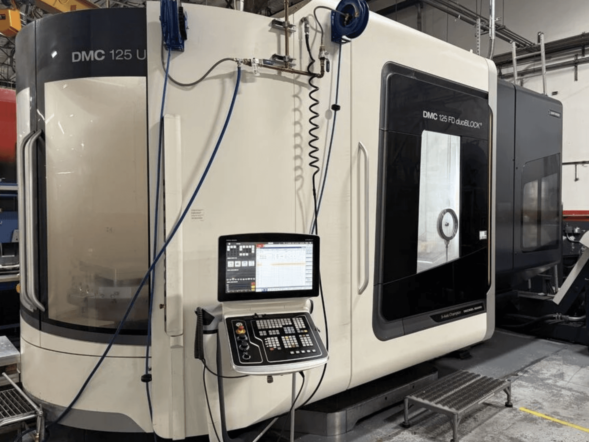DMG MORI DMC 125 U duoBLOCK -yleiskone, etunäkymä ohjauspaneelin ja heijastavien pintojen kanssa.