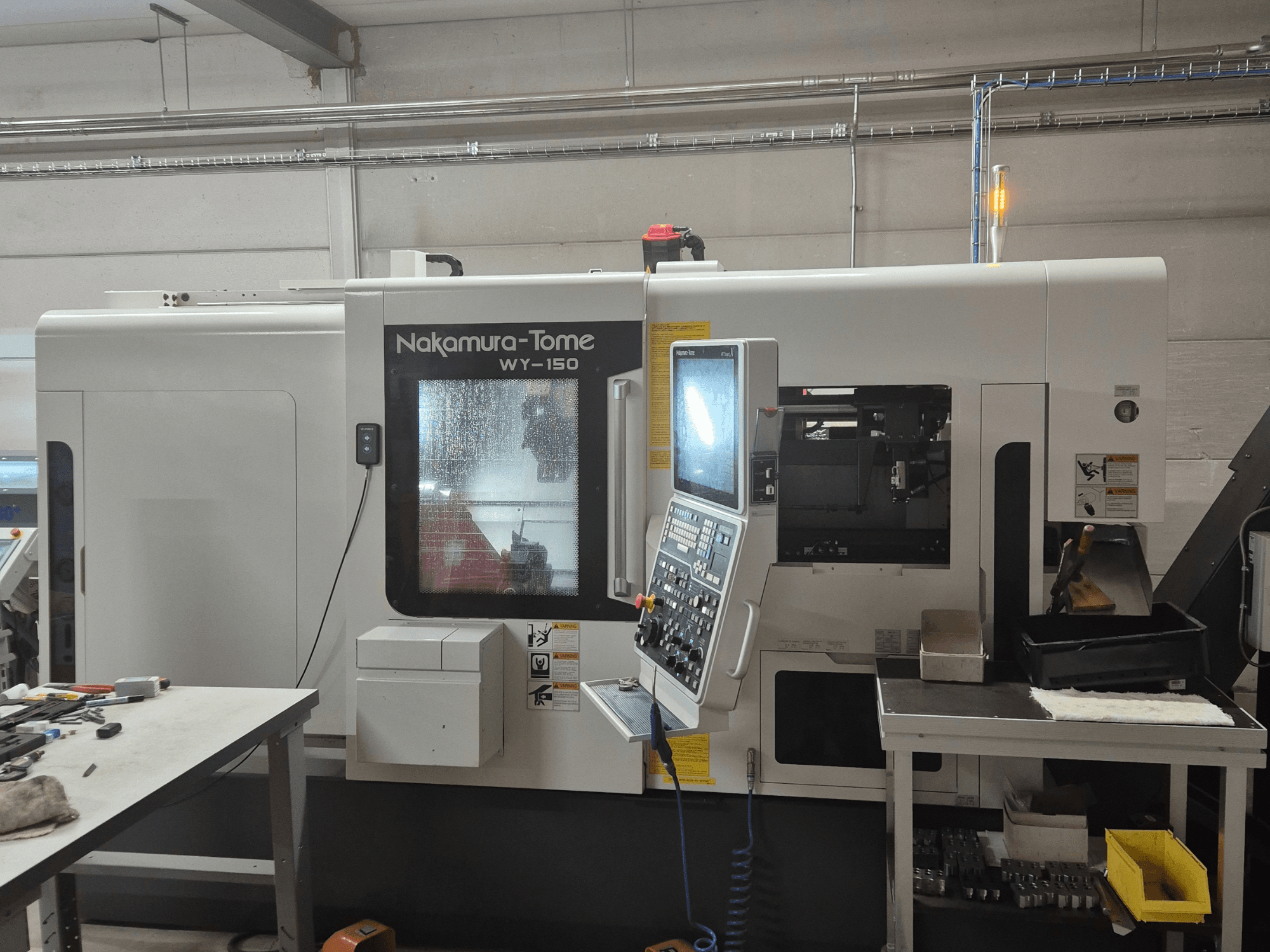 Nakamura-Tome WY-150 CNC-sorvi sivukuvassa, jossa on ohjauspaneeli, läpinäkyvä ikkuna ja näkyvä työalue.