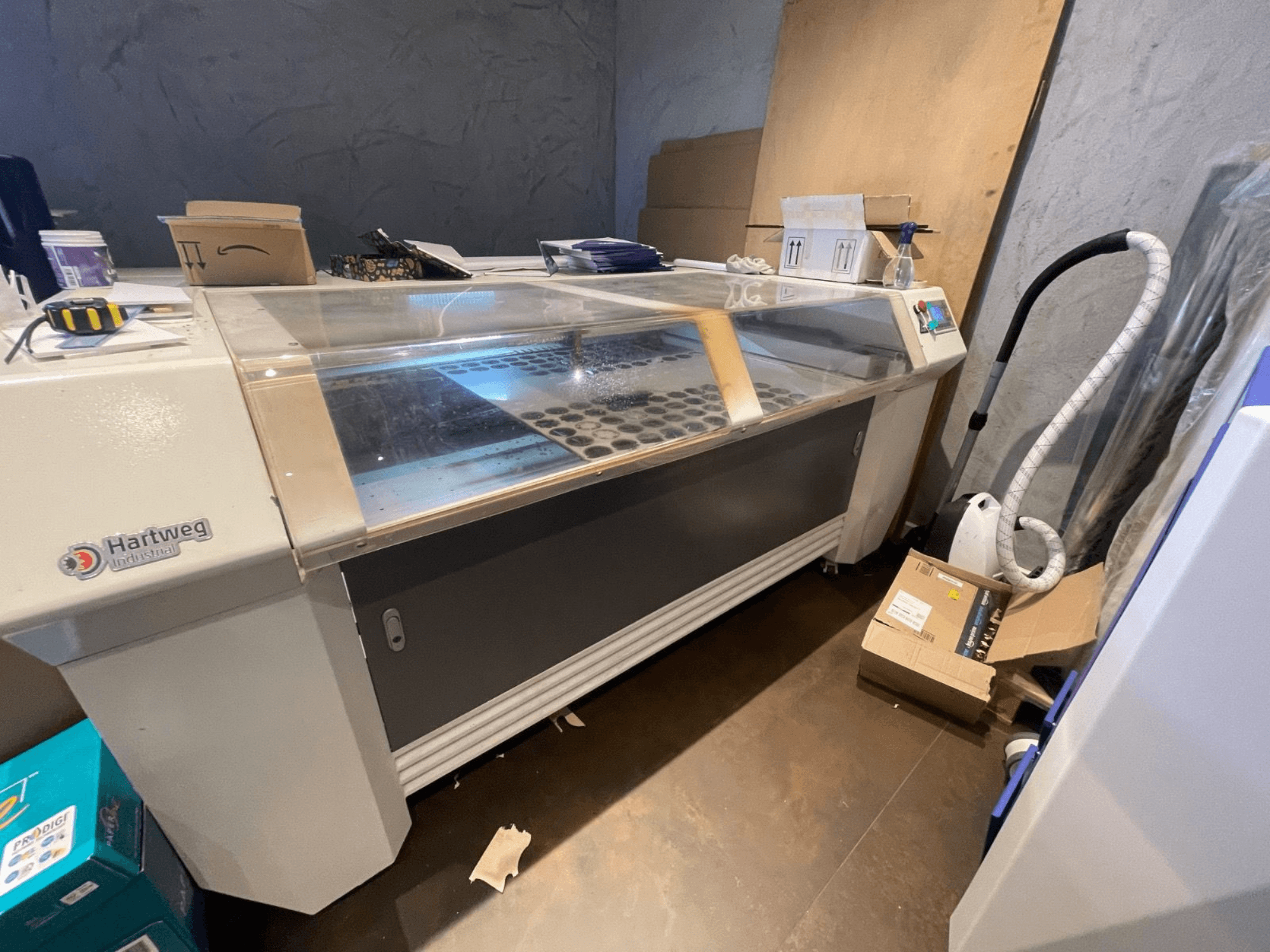 CO2-laserleikkauskone Bodor CL-1610XUF sivukuvassa, jossa näkyy työalue, materiaaliaukot ja ohjauspaneeli.