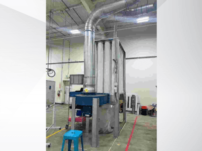 Suuri teollinen ilmanvaihtojärjestelmä, etukuva, jossa on kiiltävä metallikanava ja sininen pohja, tilavassa varastossa.