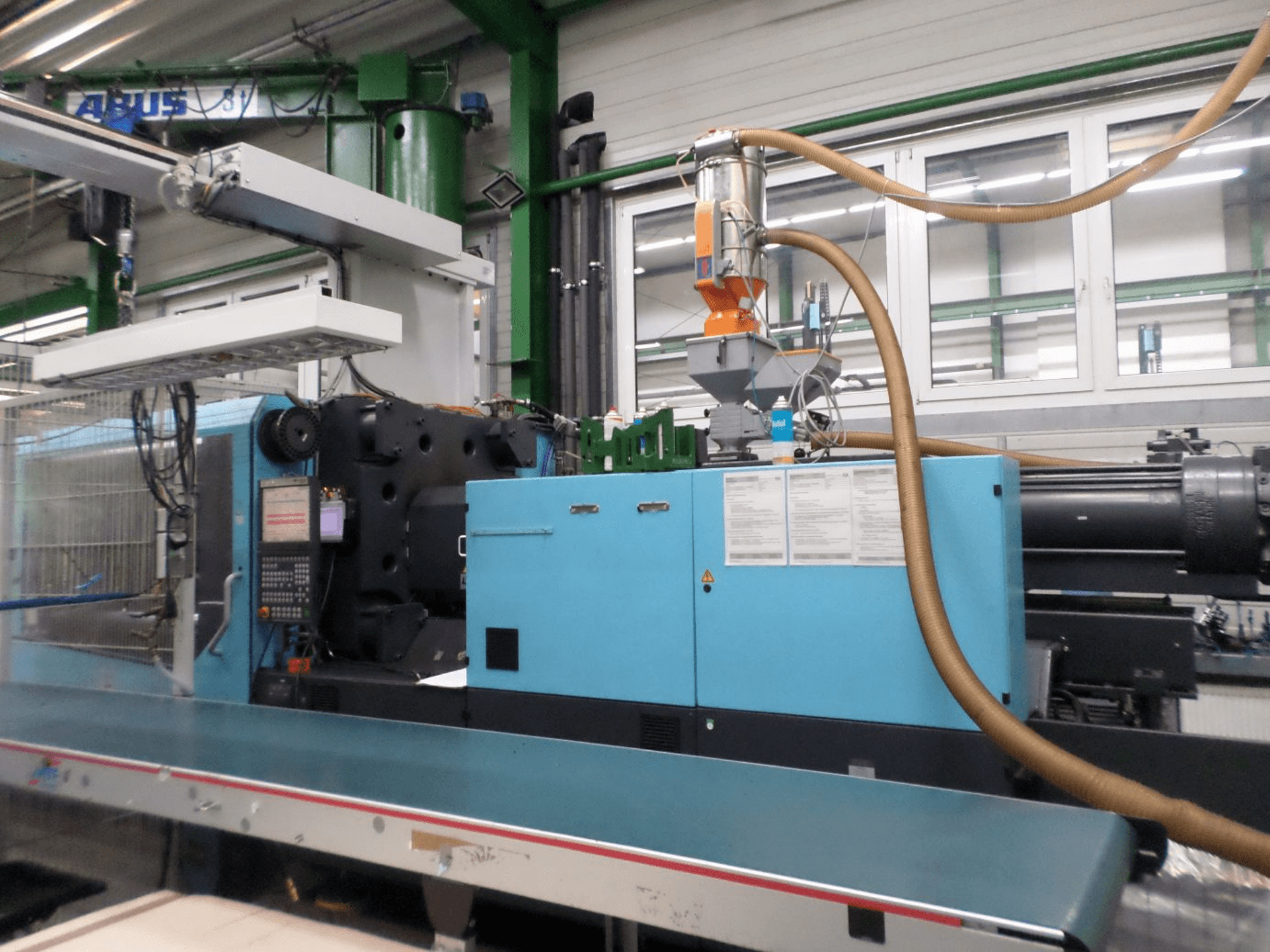 DEMAG D 420 -hydraulisen ruiskuvalukoneen etunäkymä, jossa näkyvät ohjauspaneeli, syöttösuppilo ja hydrauliikkakomponentit.