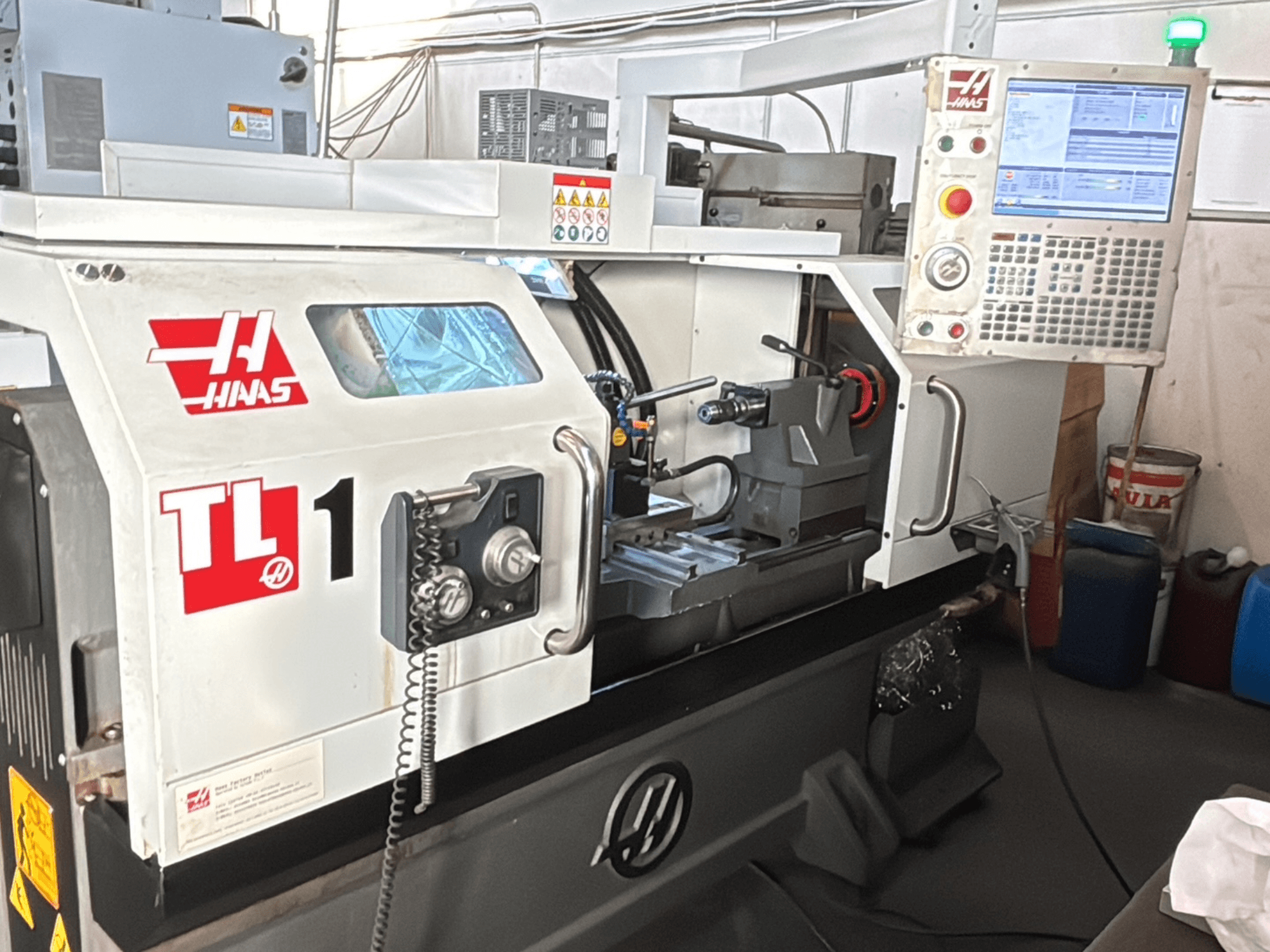 Haas TL-1 CNC-sorvi, etukuva, jossa on ohjauspaneeli, jossa on näyttö, työkalunpidin ja turvatarrat.