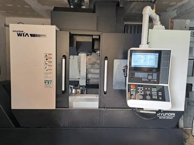 Hyundai WIA F500 Plus CNC-kone etukuvassa, jossa on digitaalinen ohjauspaneeli ja turvatarrat.