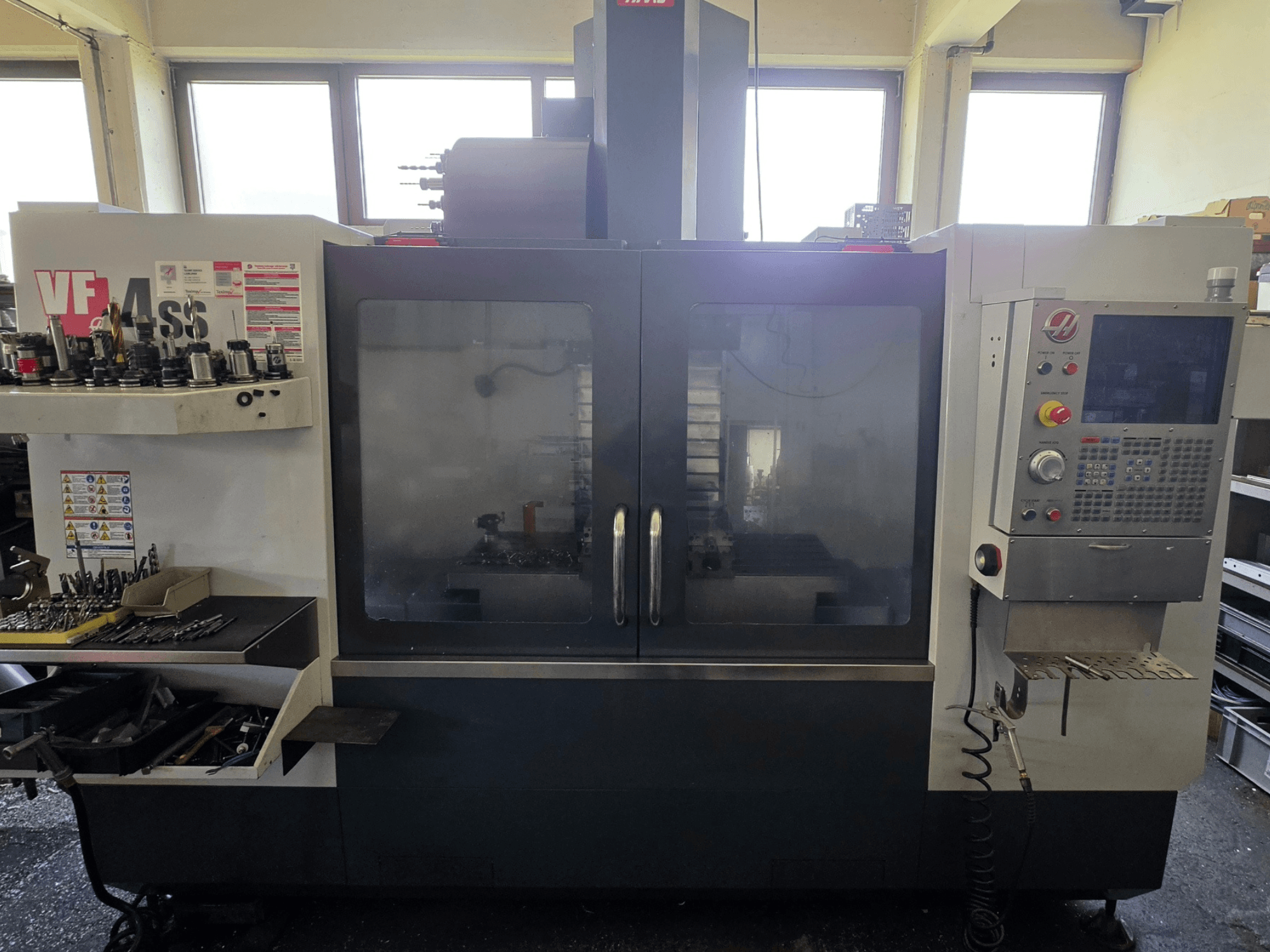 HAAS VF 34SS -pystytyöstökeskuksen etukuva, jossa näkyy ohjauspaneeli ja työkalujen säilytystila.