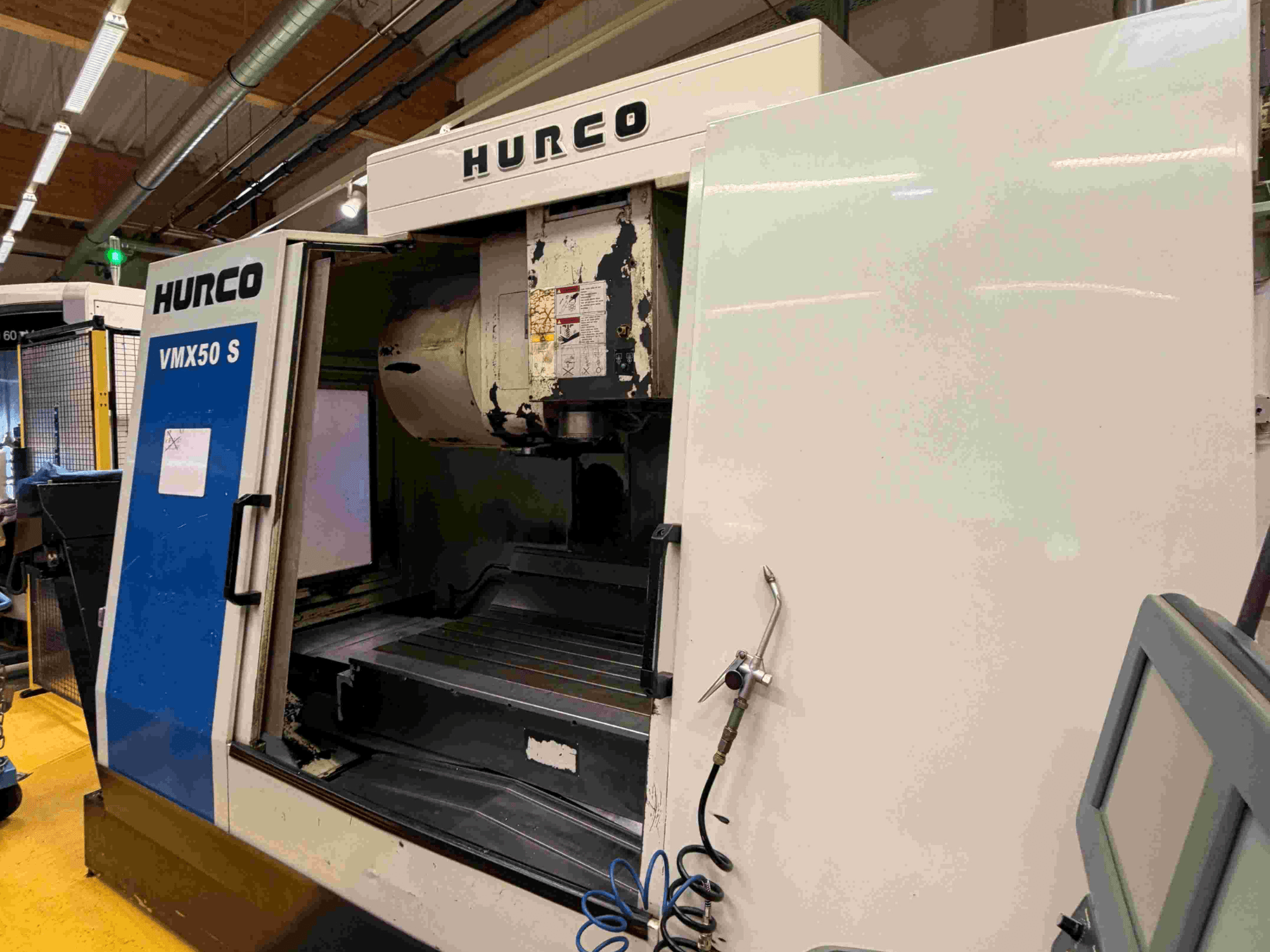 Hurco VMX50 S -pystytyöstökeskus, sivukuva, jossa näkyy avoin ovi ja ohjauspaneeli.