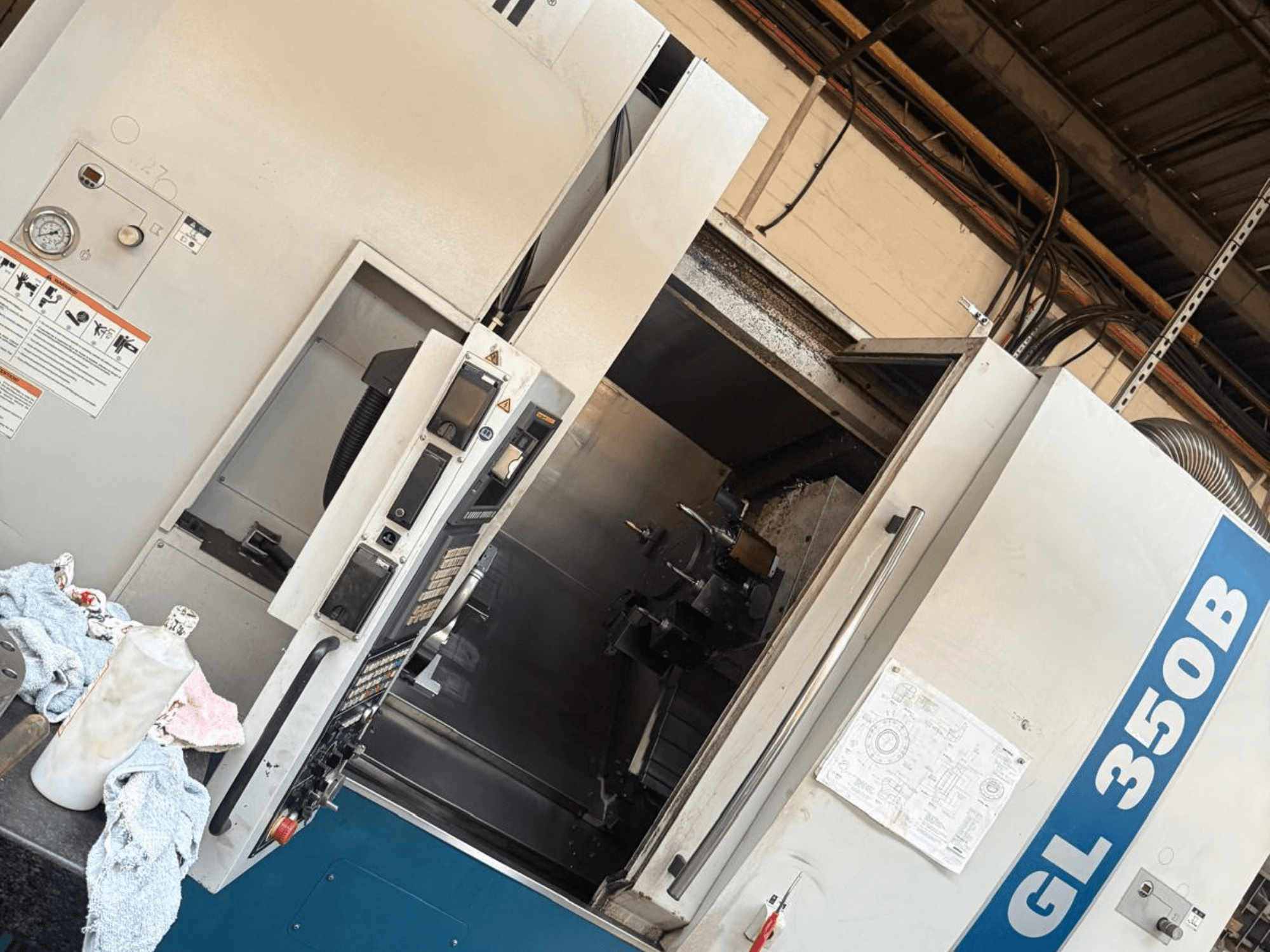 Vaakasuuntainen sorvauskone Romi GL 350B, etukuva, jossa on ohjauspaneeli ja avattu ovi, joka paljastaa sisätilat.