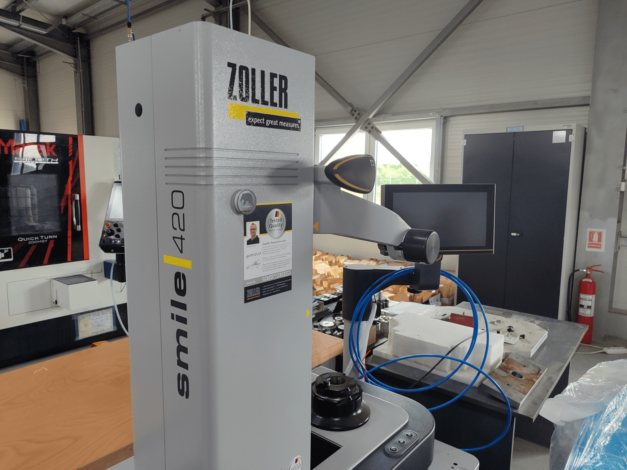 ZOLLER smile 420 -mittalaite monitorilla, sivukuva korjaamolla, taustalla siniset letkut ja koneet.