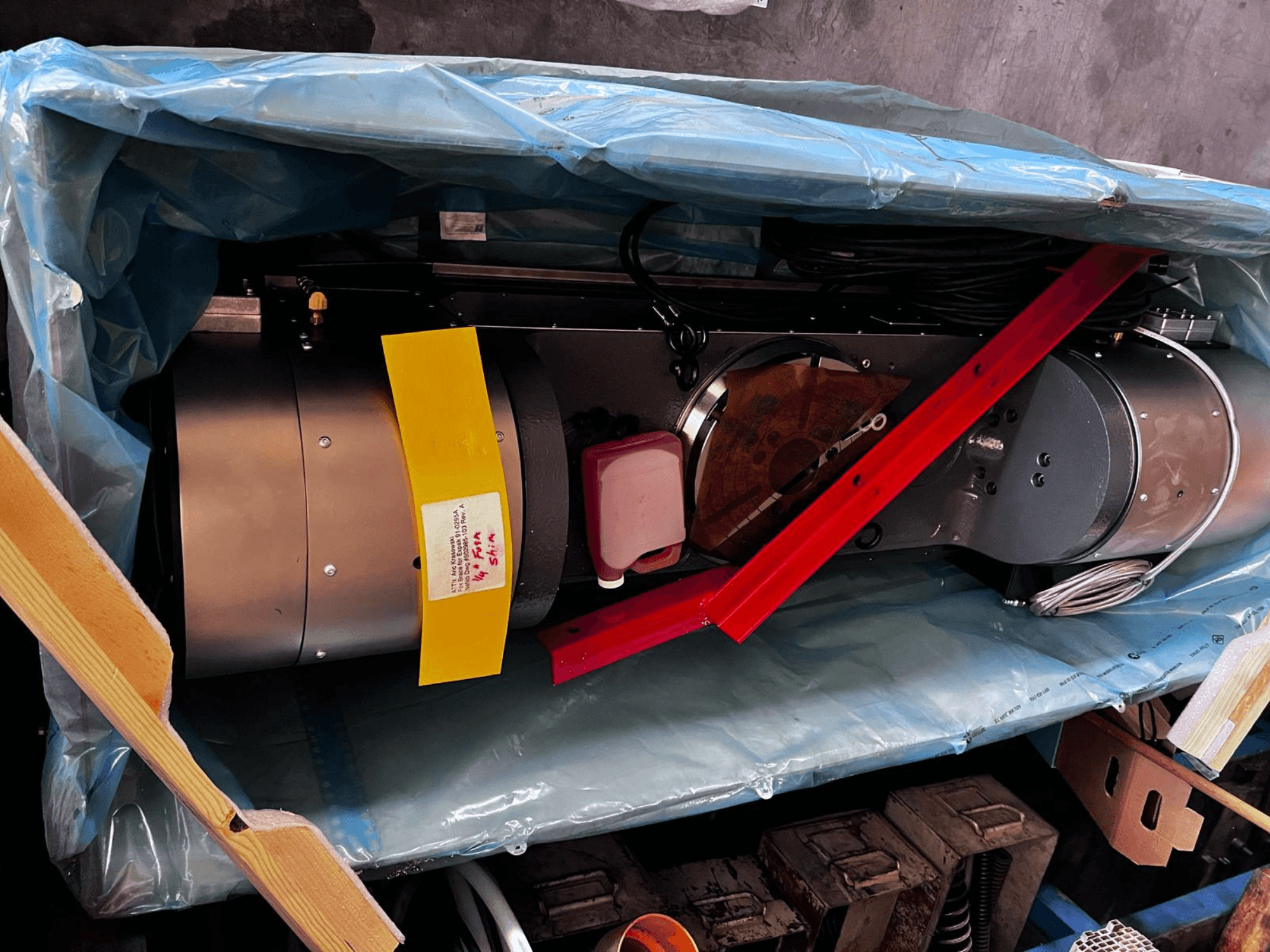 Moottorilaite näkyy osittain pakkauksessa, siinä on hopeinen ulkopinta, värikkäät mittarit ja punainen tukirauta.