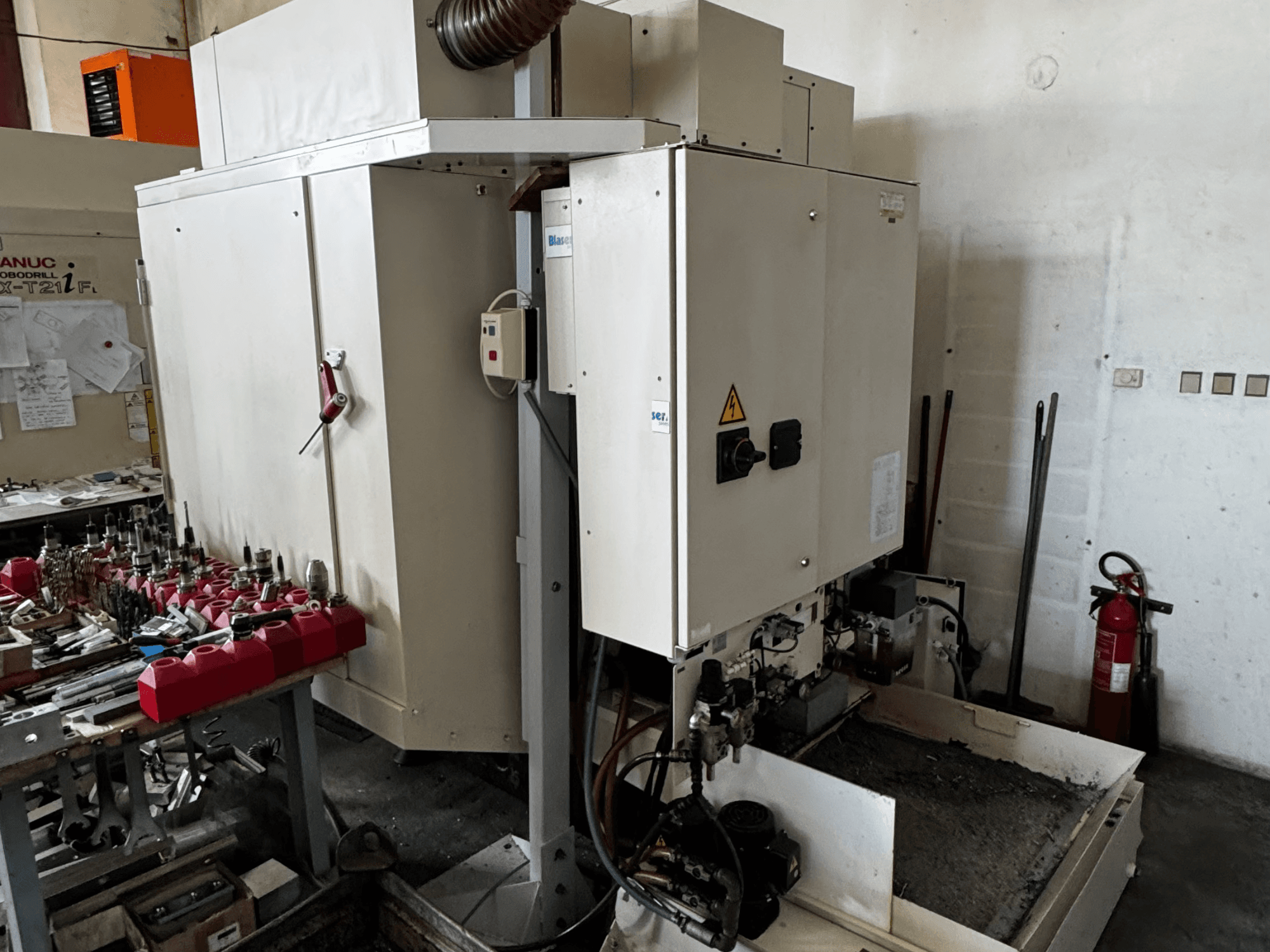 FANUC Robodrill alpha-T21iFL -pystytyöstökeskus, sivukuva, jossa näkyy ohjauspaneeli, työkalut ja työtila.