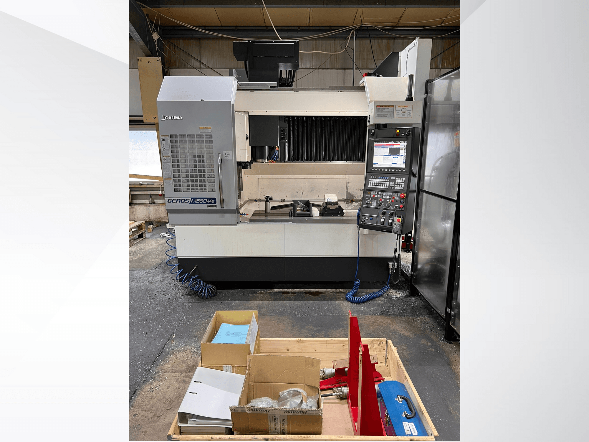 Okuma GENOS M460V-5 -pystytyöstökeskus, etukuva, ohjauspaneeli näkyvissä ja työkalut työpöydällä.