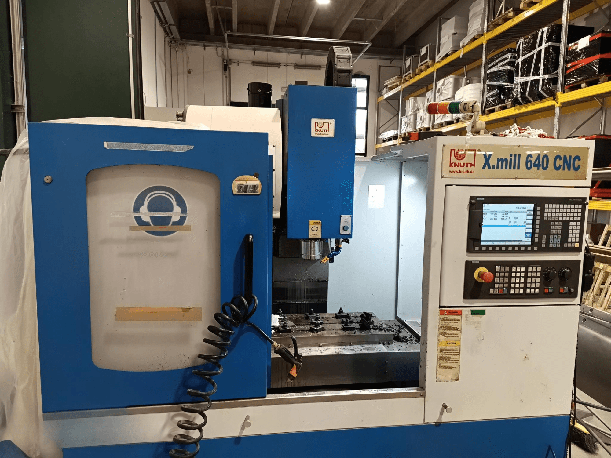 Knuth X.mill 640 CNC-kone sivukuvassa, jossa on ohjauspaneeli, karan alue ja näkyvä työkappaleen asetus.