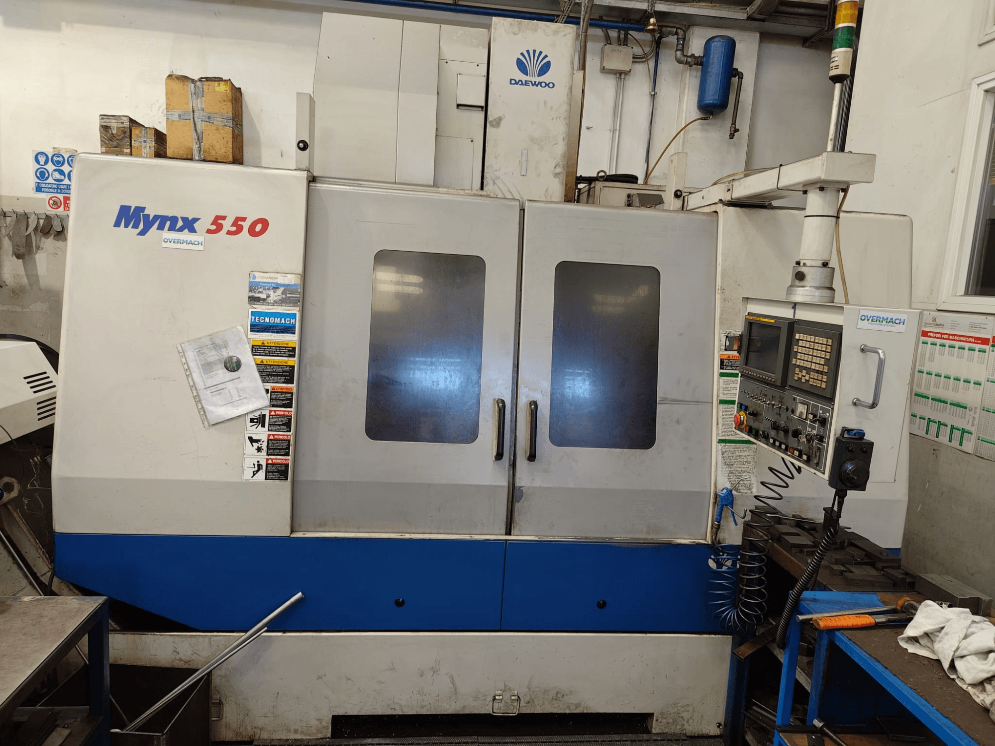 DAEWOO MYNX 550 -pystykoneistuskeskus, etunäkymä, jossa näkyvät ohjauspaneeli, kaksi suurta ovea ja turvallisuusmerkinnät.