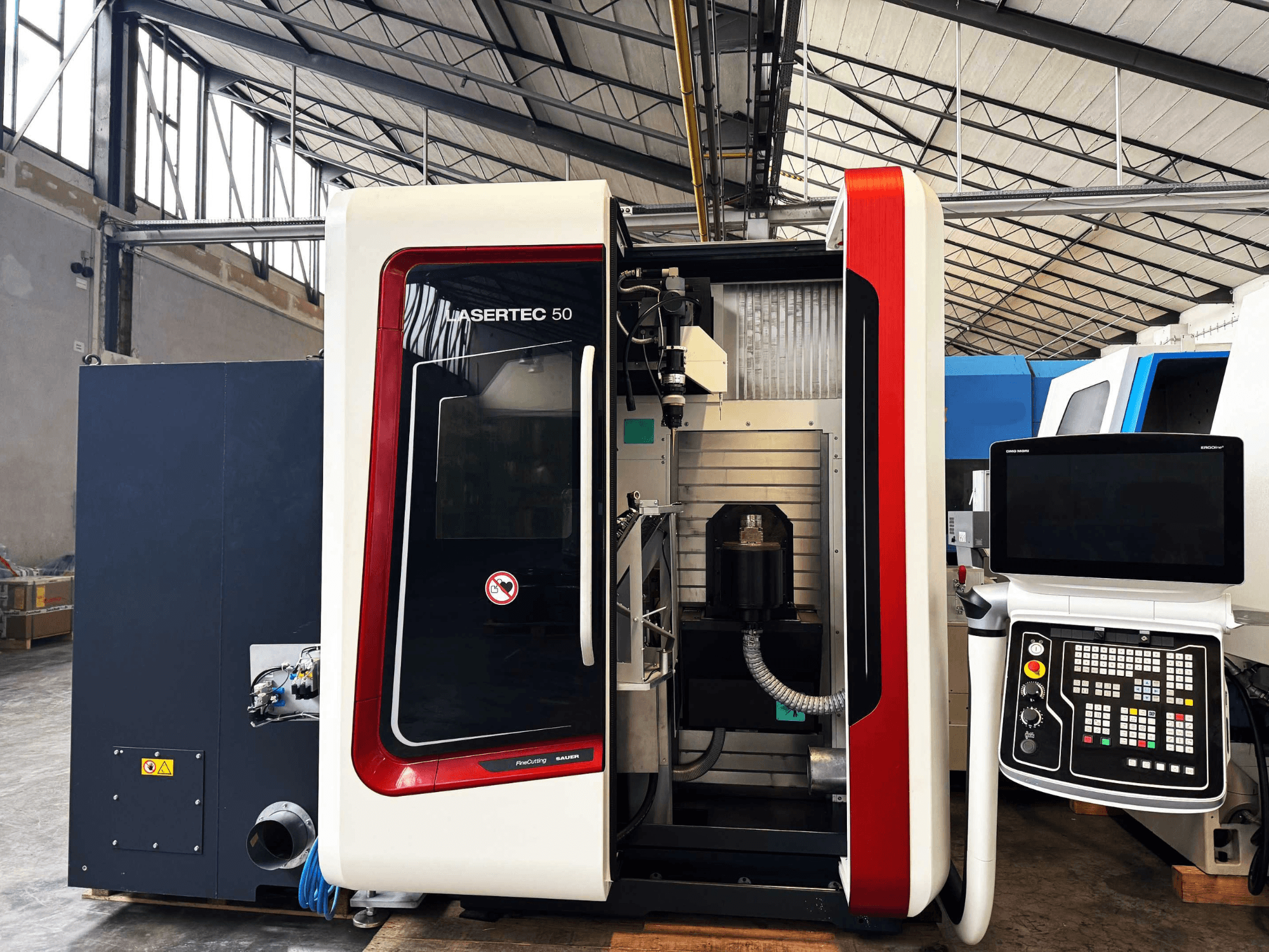 LaserTec 50 CNC-kone sivukuvassa, jossa on mustavalkoinen ohjauspaneeli, näkyvä työkalunpidin ja teollisuusasetukset.