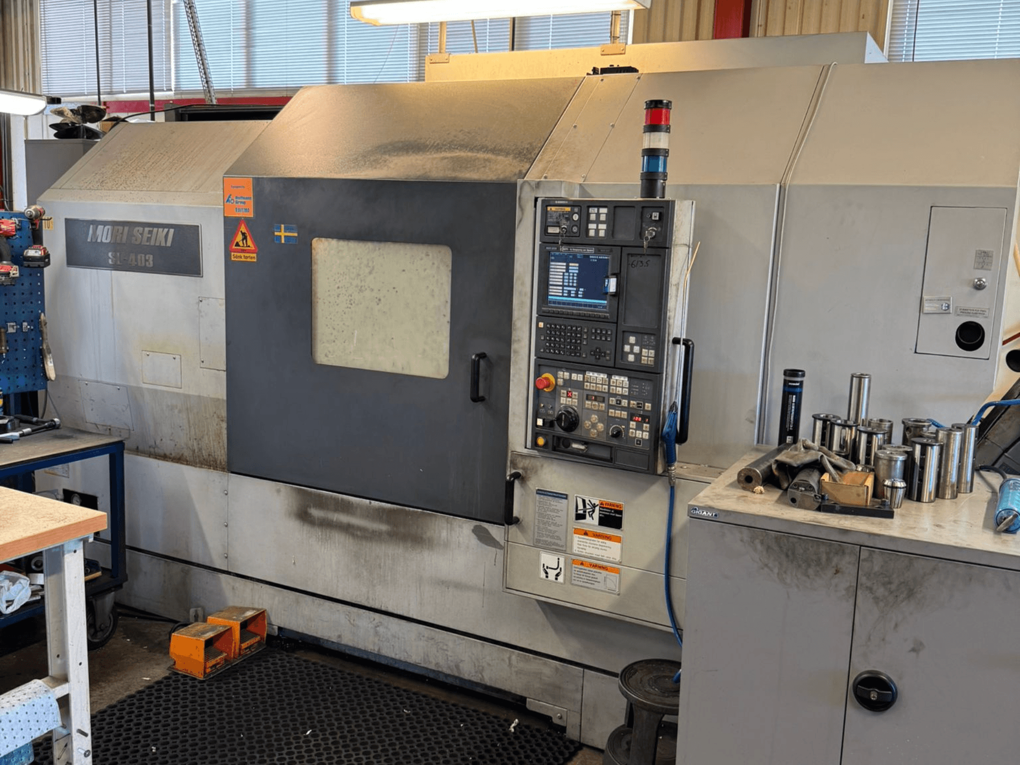 MORI SEIKI SL-403BMC/800 vaakasuuntainen sorvauskone työpajassa, jossa näkyy ohjauspaneeli ja lähellä olevat työkalut, sivukuva.