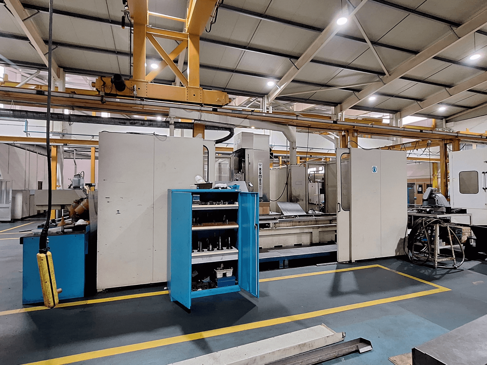 Gantry-jyrsin Rambaudi RX 1250, etukuva työkalujen säilytystilalla, tilavassa teollisessa työtilassa.