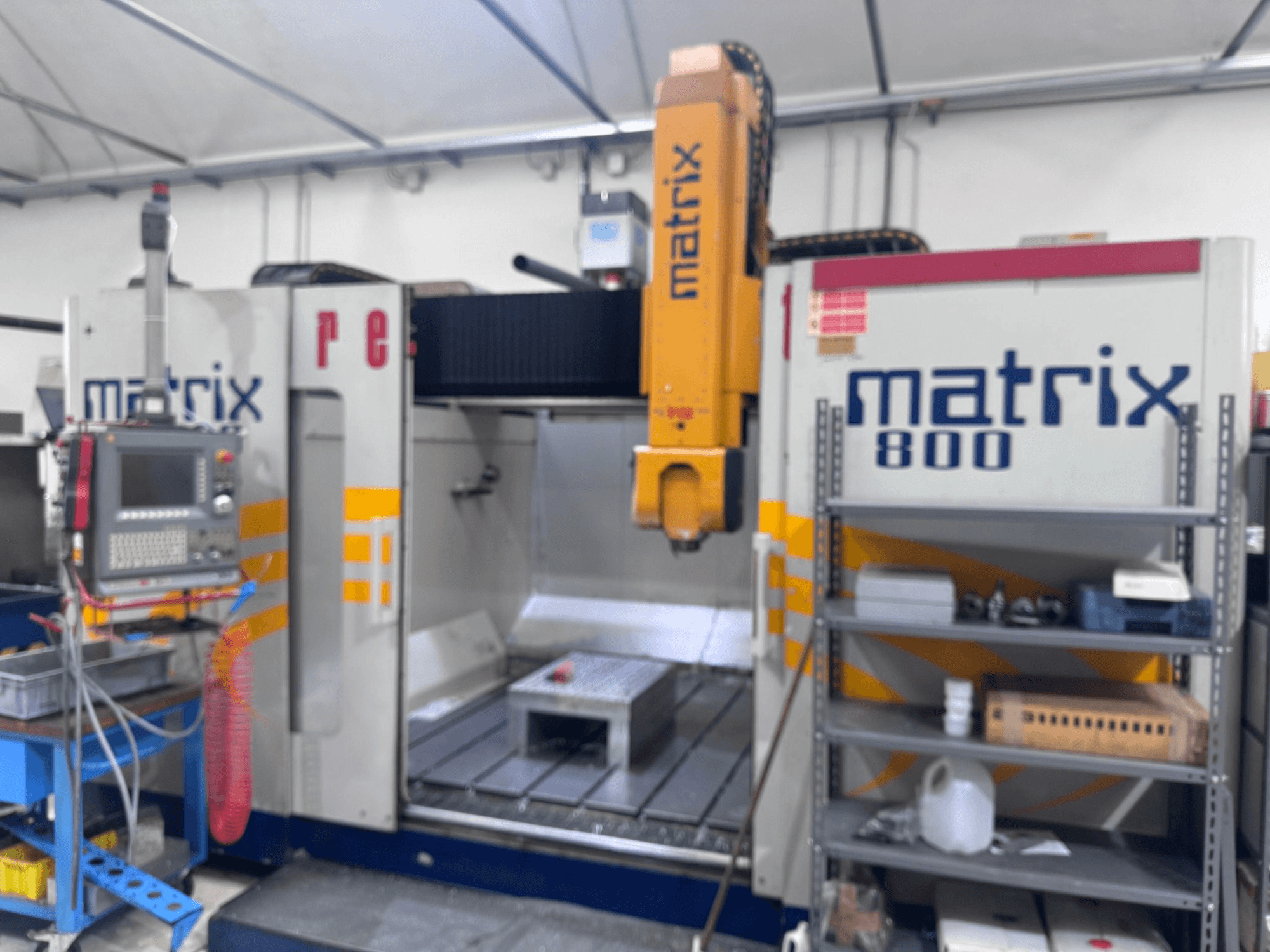 Matrix 800 CNC-kone työpajanäkymässä, jossa on ohjauspaneeli, työkaluja ja työpöytä, jossa on erilaisia esineitä.