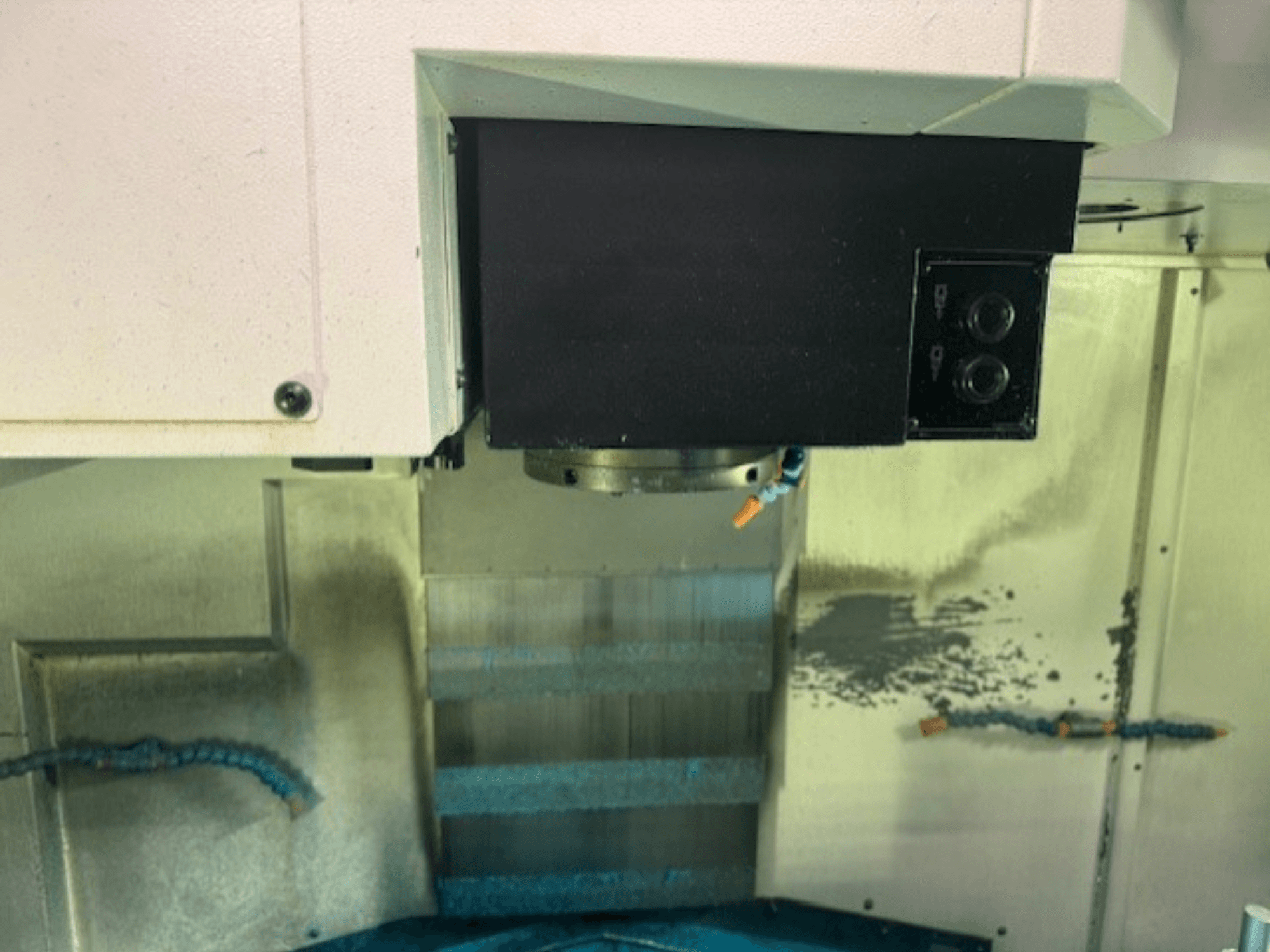 Lähikuva CNC-jyrsinkoneen ohjauspaneelista ja työkalunpitimestä, jossa näkyvät tuotemerkin yksityiskohdat, painikkeet ja työtaso.