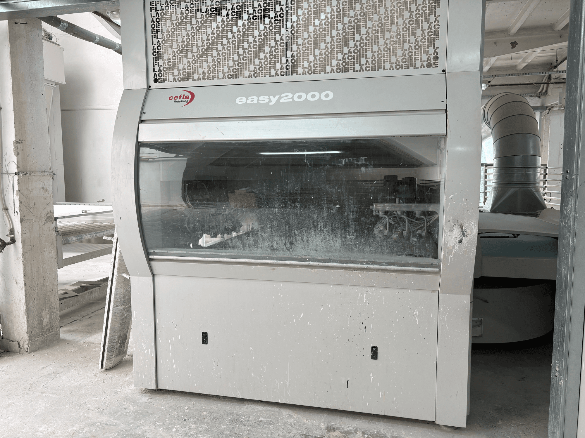 Cefla EASY 2000 D -kone edestä katsottuna; siinä on suuri läpinäkyvä paneeli, pölyinen pinta ja näkyvissä olevat sisäosat.