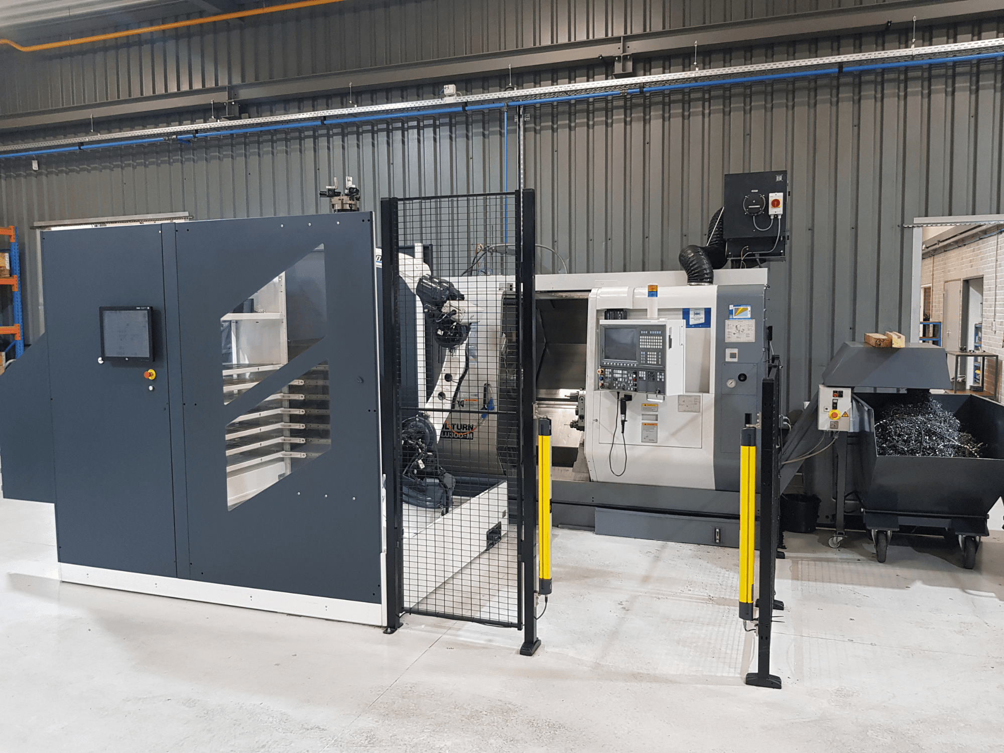 ALTURN-automaattisorvi ja CNC-kone tehdasympäristössä; etukuva, jossa ohjauspaneeli ja suoja-aita näkyvissä.