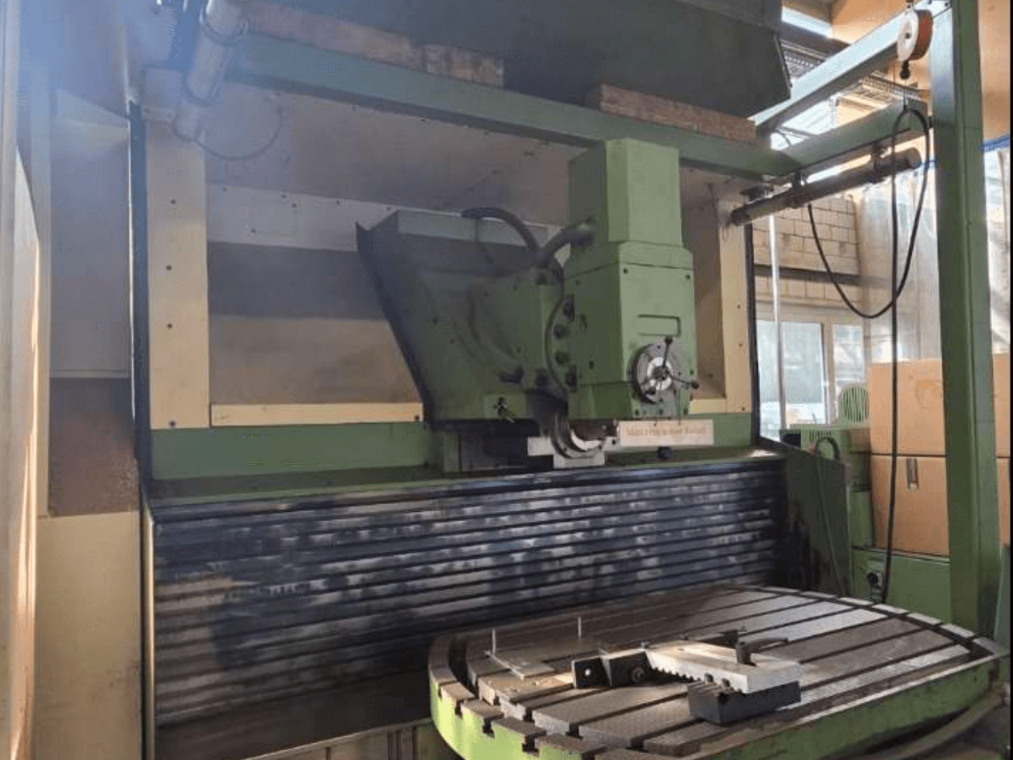 MAHO MH1000 C -yleiskoneistuskeskus edestäpäin, jossa näkyy vihreä rakenne, kara ja pyörivä pöytä työkappaleen kanssa.