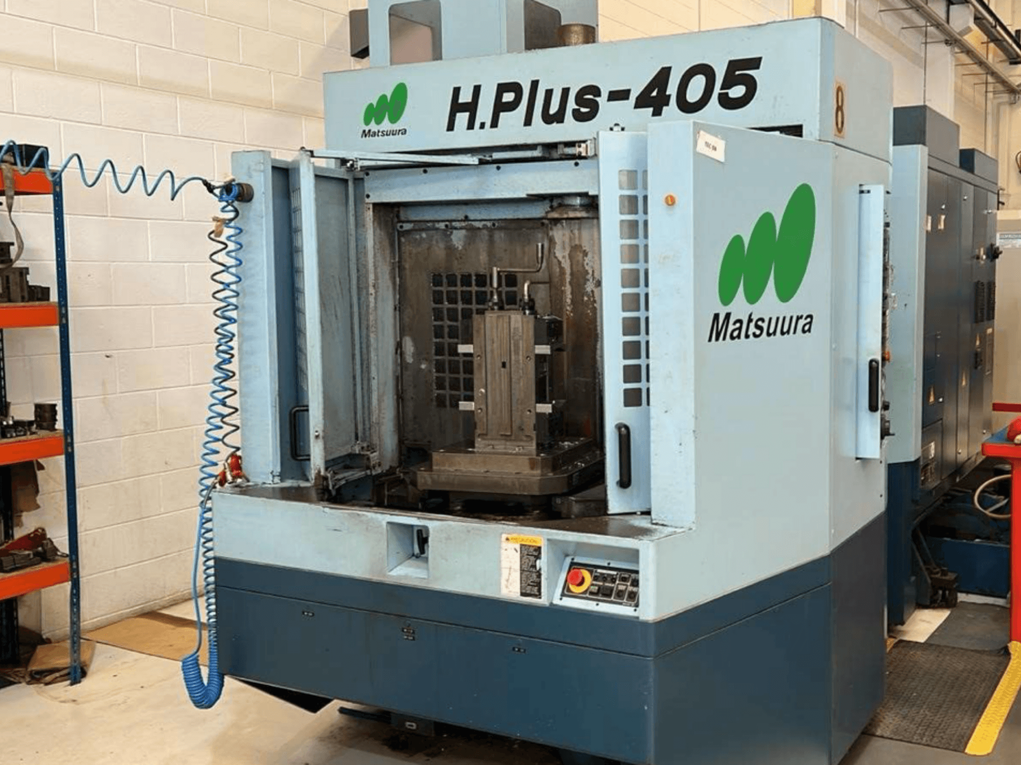 Matsuura H.Plus 405 -vaakakoneistuskeskus edestä katsottuna, ovi auki, jolloin työtila ja ohjauspaneeli näkyvät selvästi.