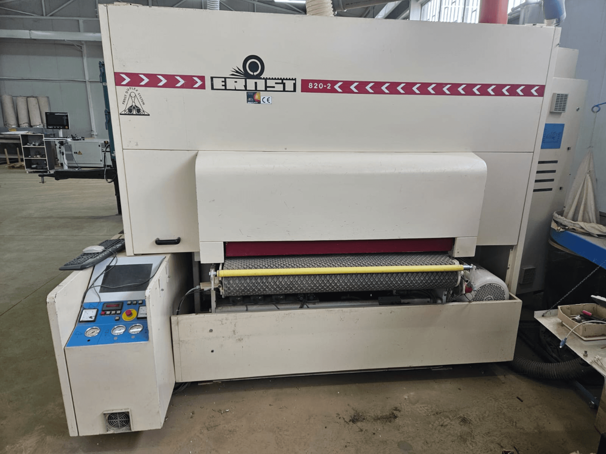 Ernst 820-2 puunjalostuskone, etukuva, jossa on ohjauspaneeli ja keltainen rulla syöttölaitteessa.