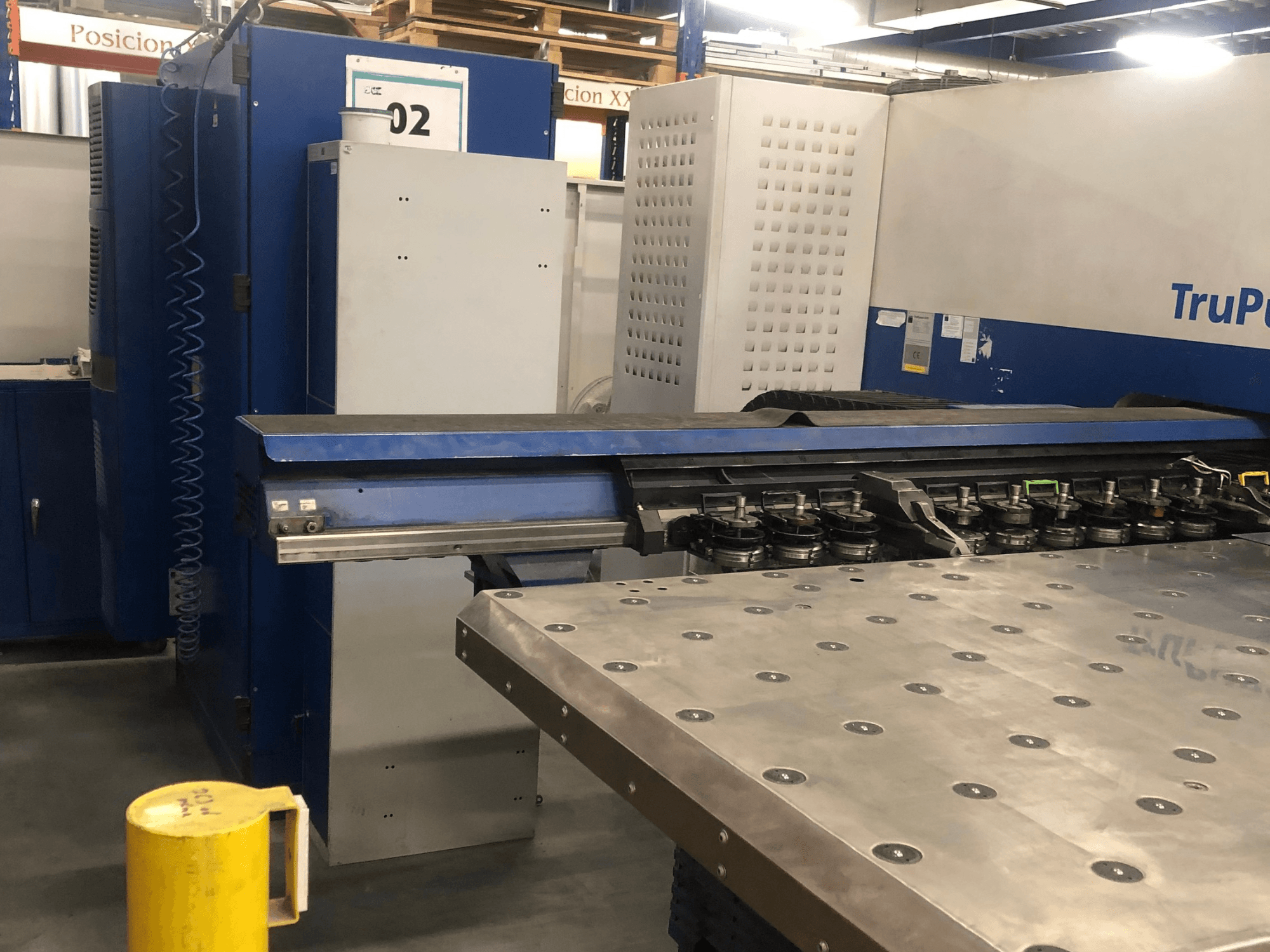 TRUMPF TruPunch 5000 CNC-lävistyskone, etunäkymä, jossa näkyy työkalutornin ja ohjauspaneeli sekä vieressä oleva metallinen työpöytä.