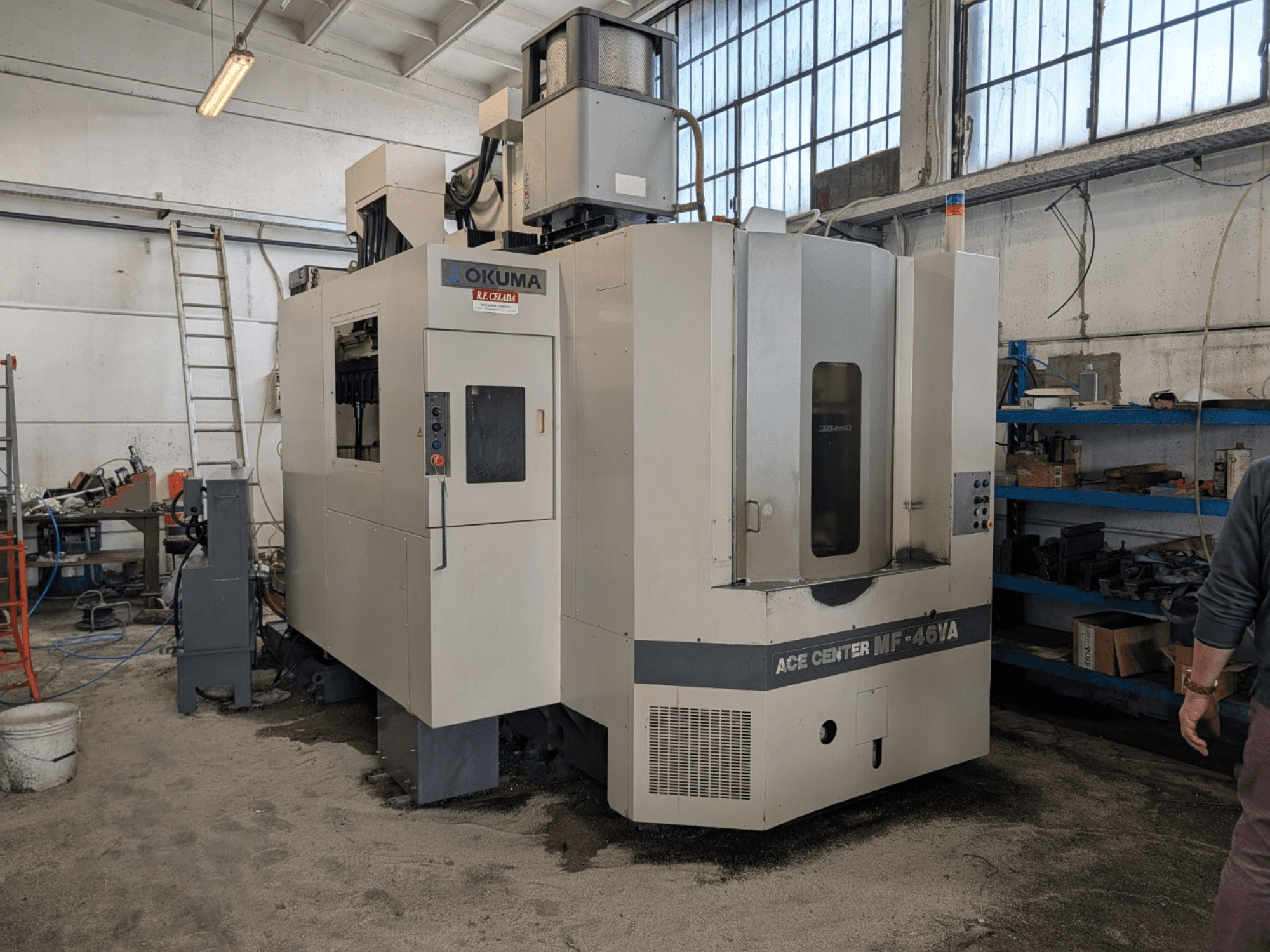 Okuma ACE CENTER MF-46VA -pystytyöstökeskus työpajassa, etunäkymä, jossa ohjauspaneeli ja ympäröivät laitteet.