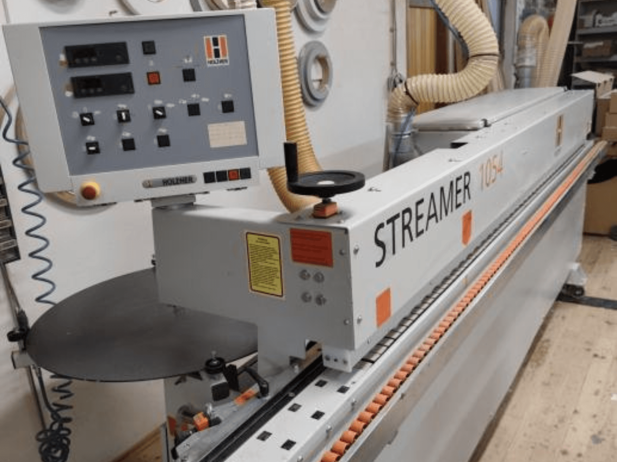 HOLZHER Streamer 1054 särmäyslaite, sivukuva ohjauspaneelista ja syöttöjärjestelmästä työpajataustalla.