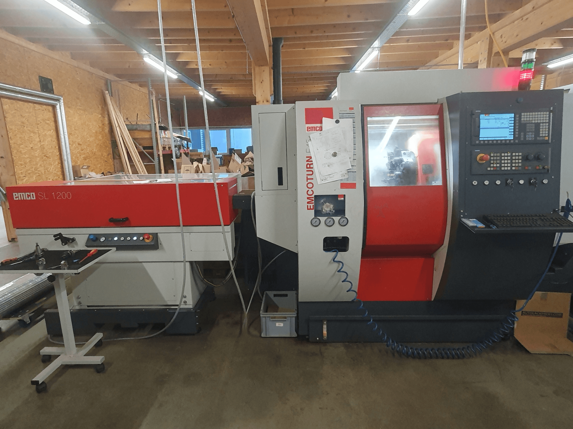 EMCO SL 1200 CNC-sorvi ja EMCOturn; etukuva, jossa näkyvät hallintalaitteet, näytöt ja käyttöindikaattorit työpajassa.