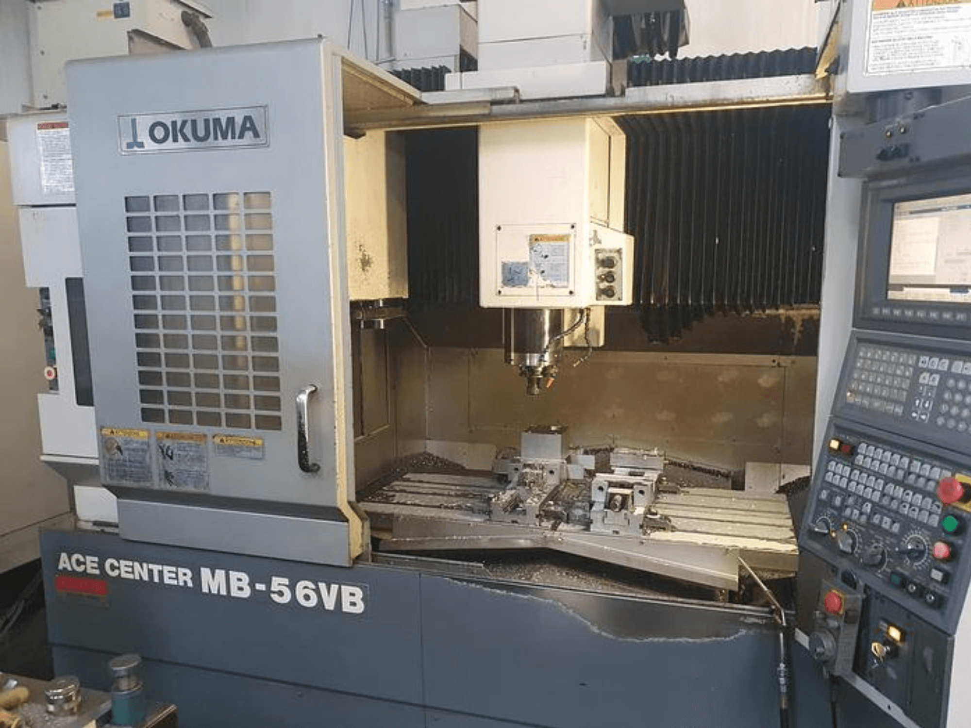 Okuma ACE CENTER MB-56VB CNC-jyrsinkone etukuvassa, jossa näkyy ohjauspaneeli ja työstöalue.