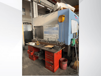 Doosan-työstökeskus, jossa on punainen työpöytä ja varastointi, jossa on työkaluja ja laitteita, edestä katsottuna.