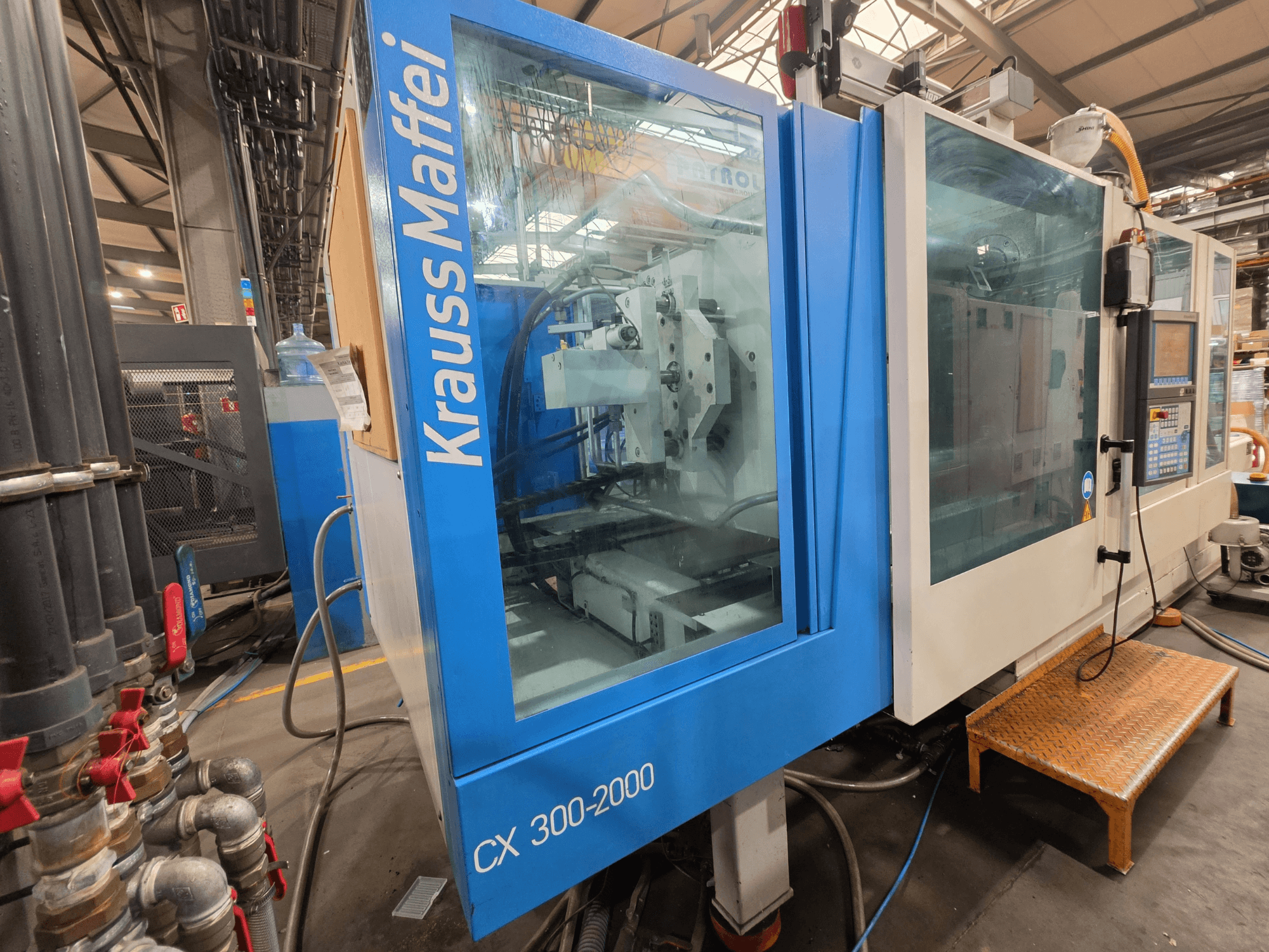 Krauss Maffei CX 300-2000 hydraulinen ruiskuvalukone, etukuva, jossa näkyy ohjauspaneeli ja hydraulilinjat.